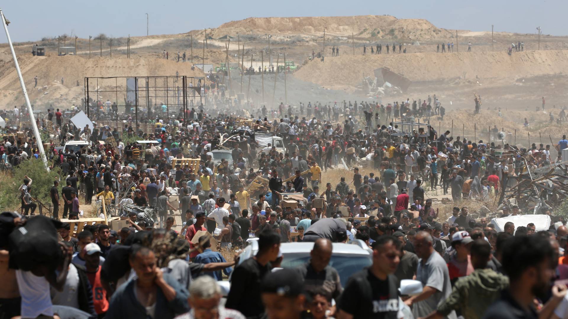 فلسطينيون يحملون مساعدات إغاثية أثناء عودتهم من مركز توزيع المساعدات في وسط قطاع غزة