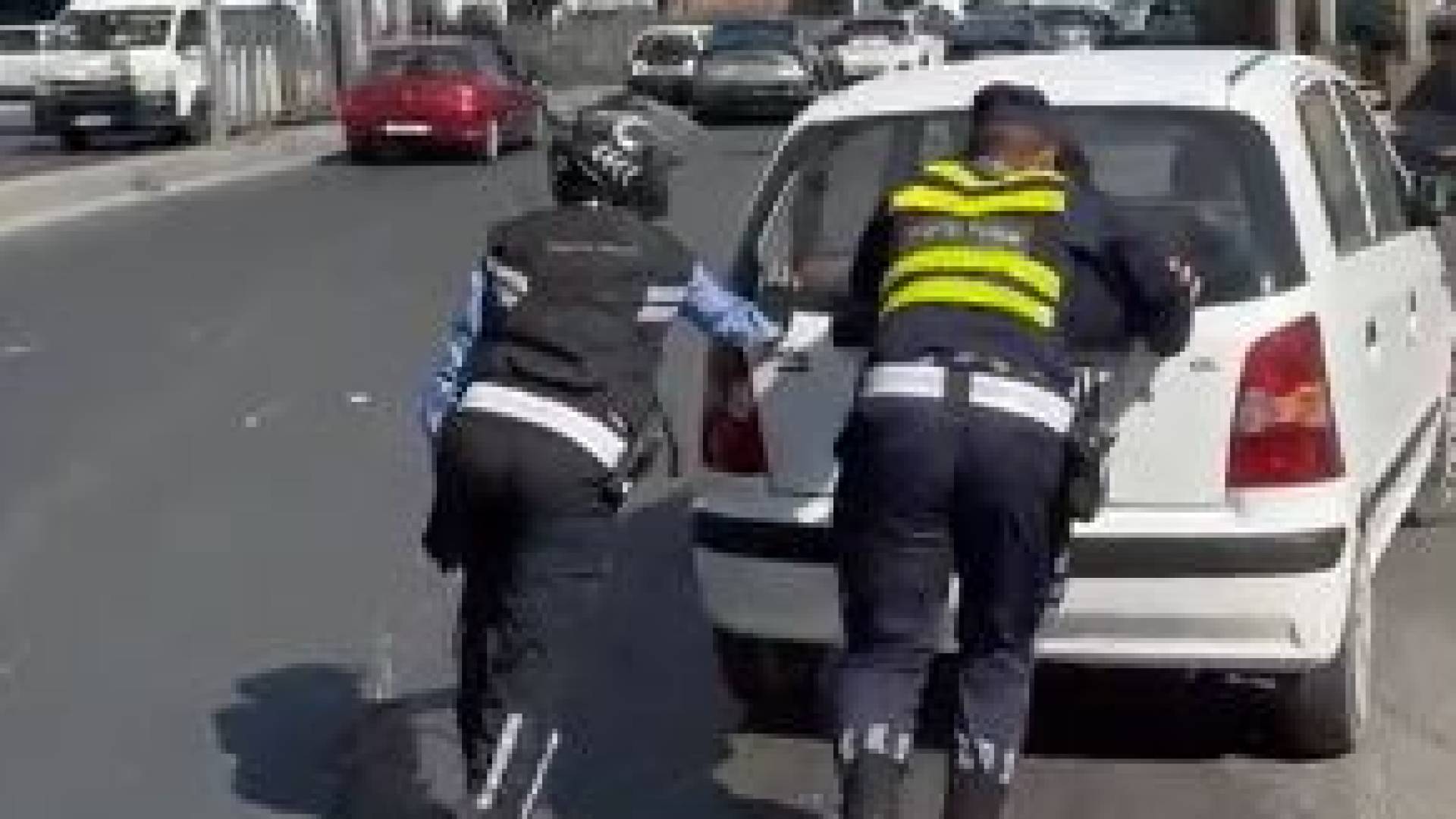 نشميان من كوادر السير يساعدان مواطنا في دفع سيارته المتعطلة في عمان