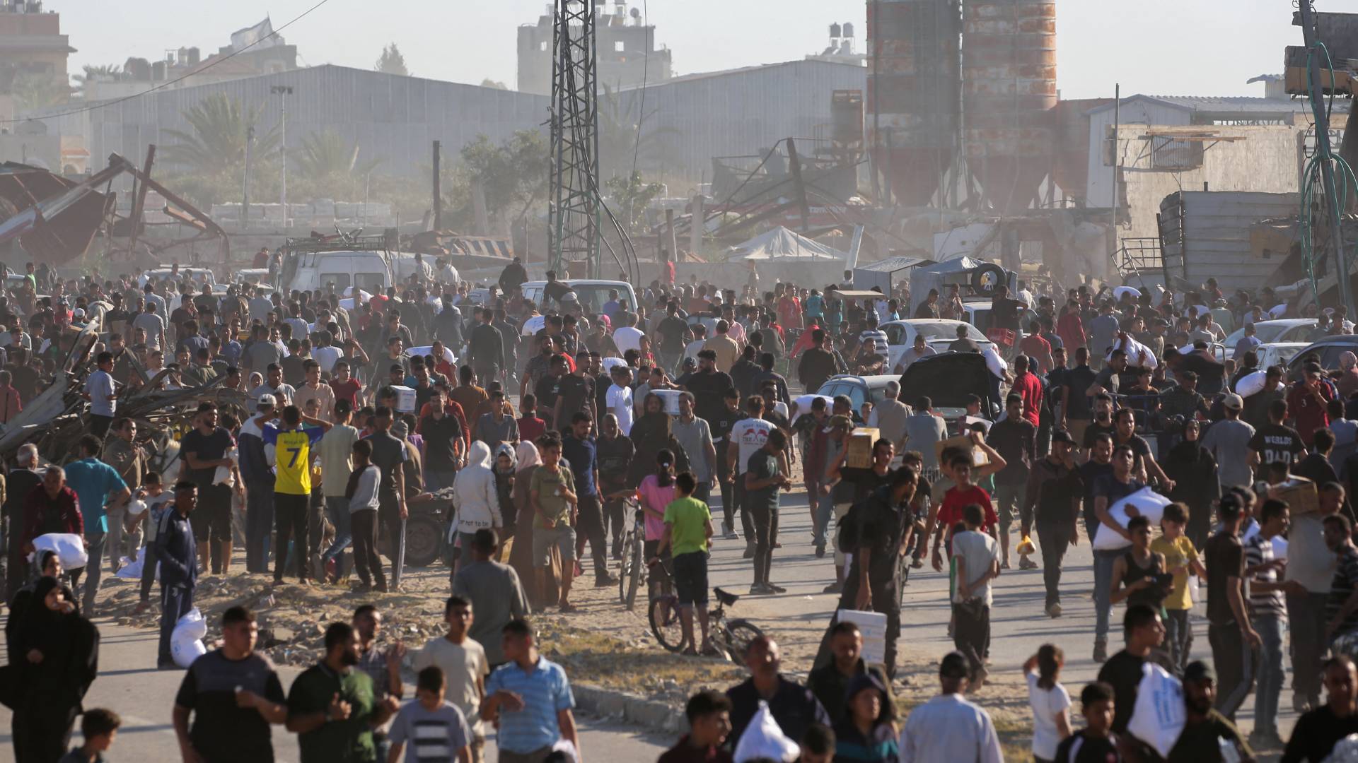 نازحون ينقلون أكياسا من المساعدات الغذائية وسط قطاع غزة