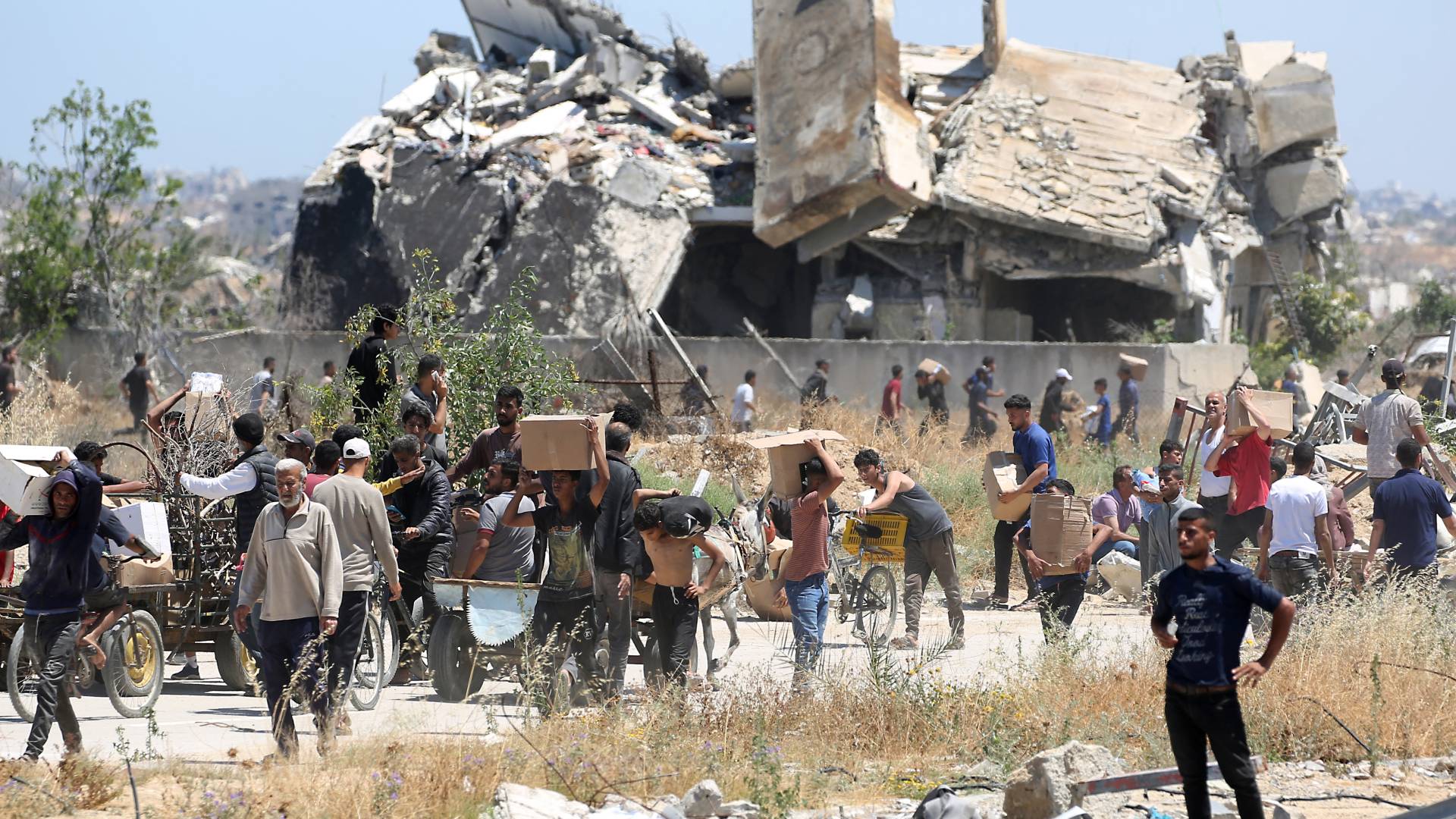 غزيون يحملون صناديق من الإمدادات الإغاثية