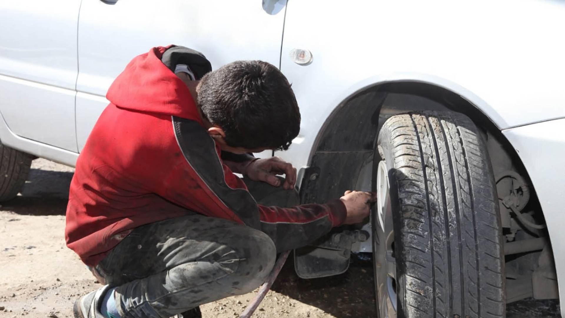 طفل يعمل في صيانة المركبات