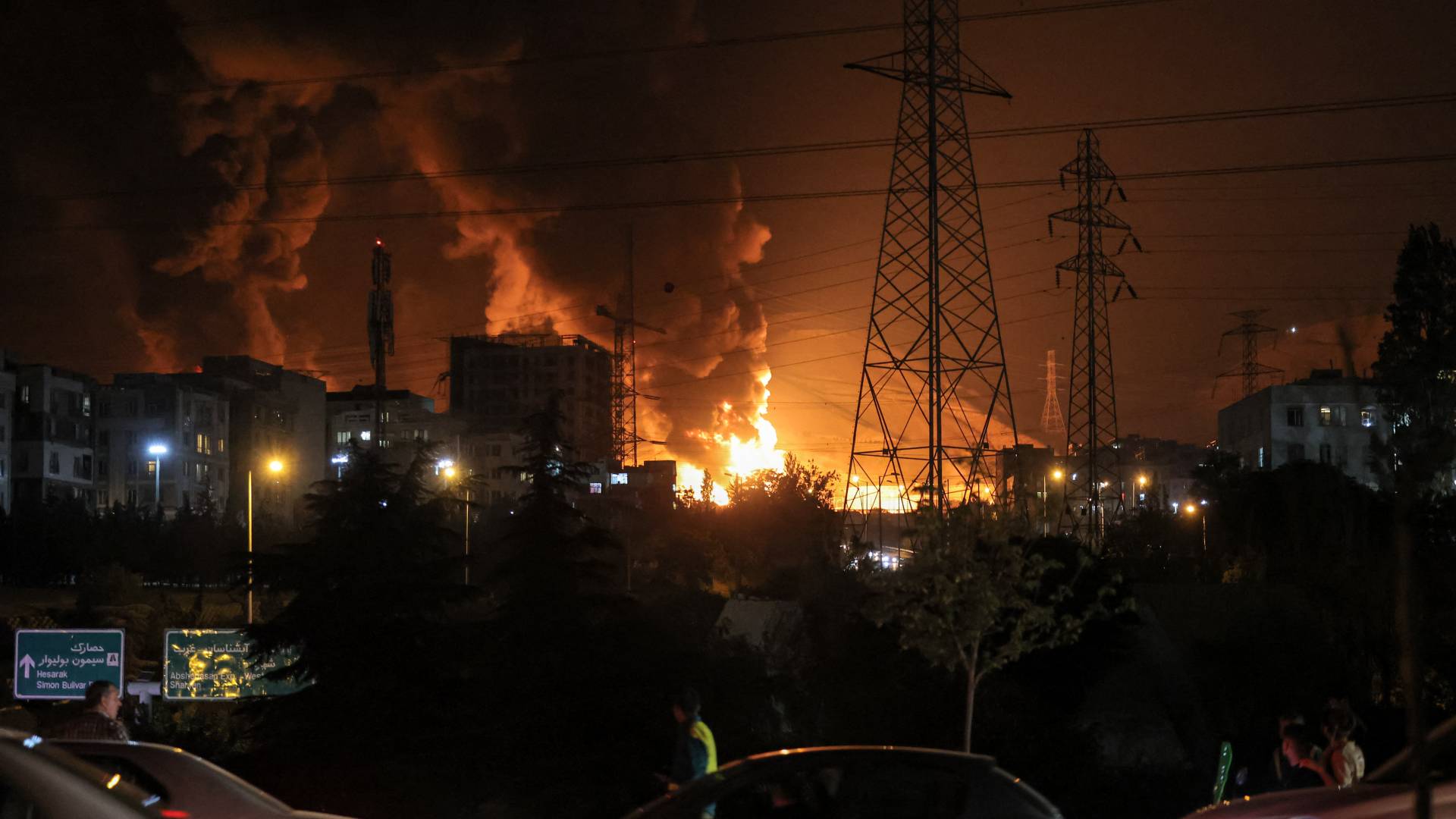 ازدحام المركبات على أحد الطرق السريعة بينما تشتعل النيران بالقرب من مستودعات النفط في منطقة شهران، شمال غرب طهران