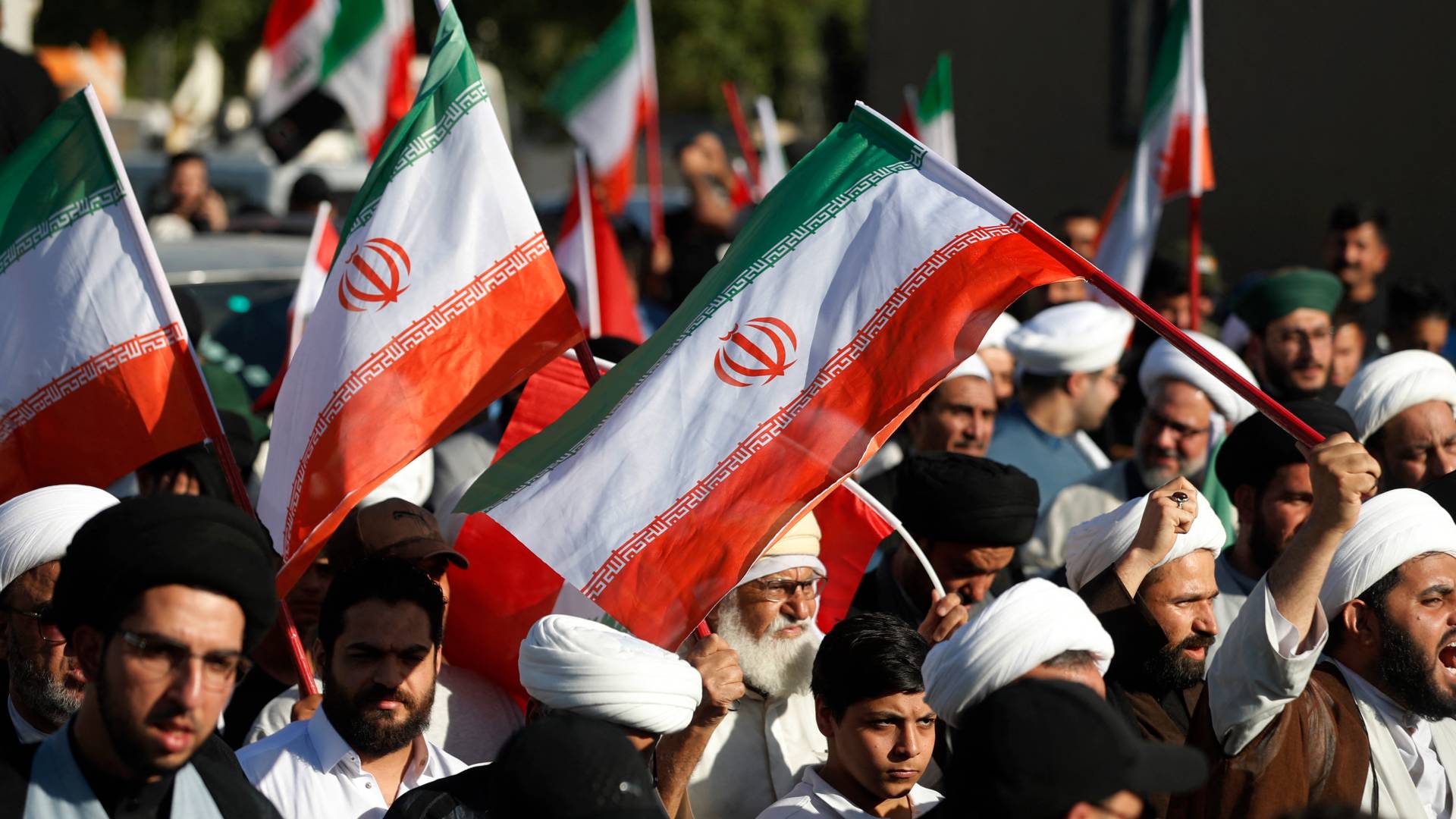 متظاهرون يرفعون أعلام إيران