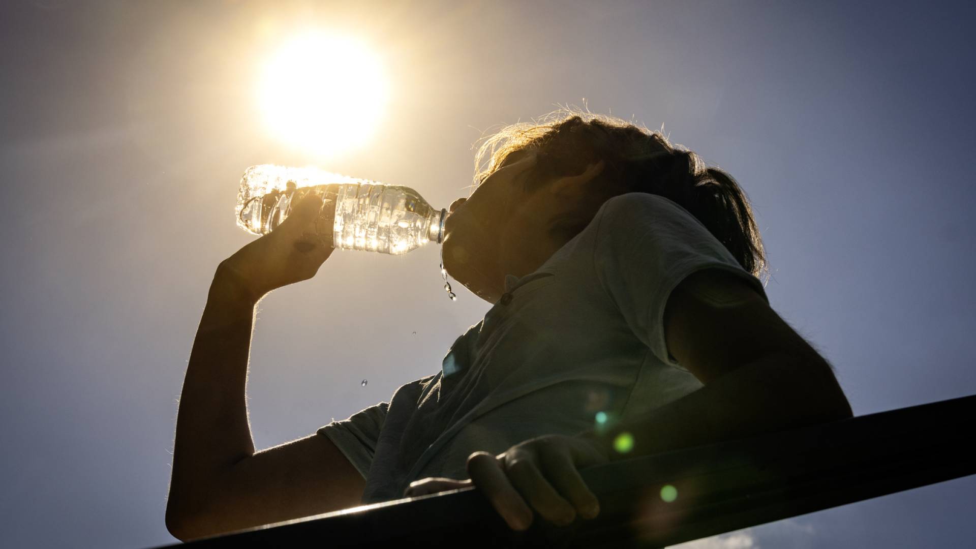 طفل يشرب الماء بسبب حرارة الطقس