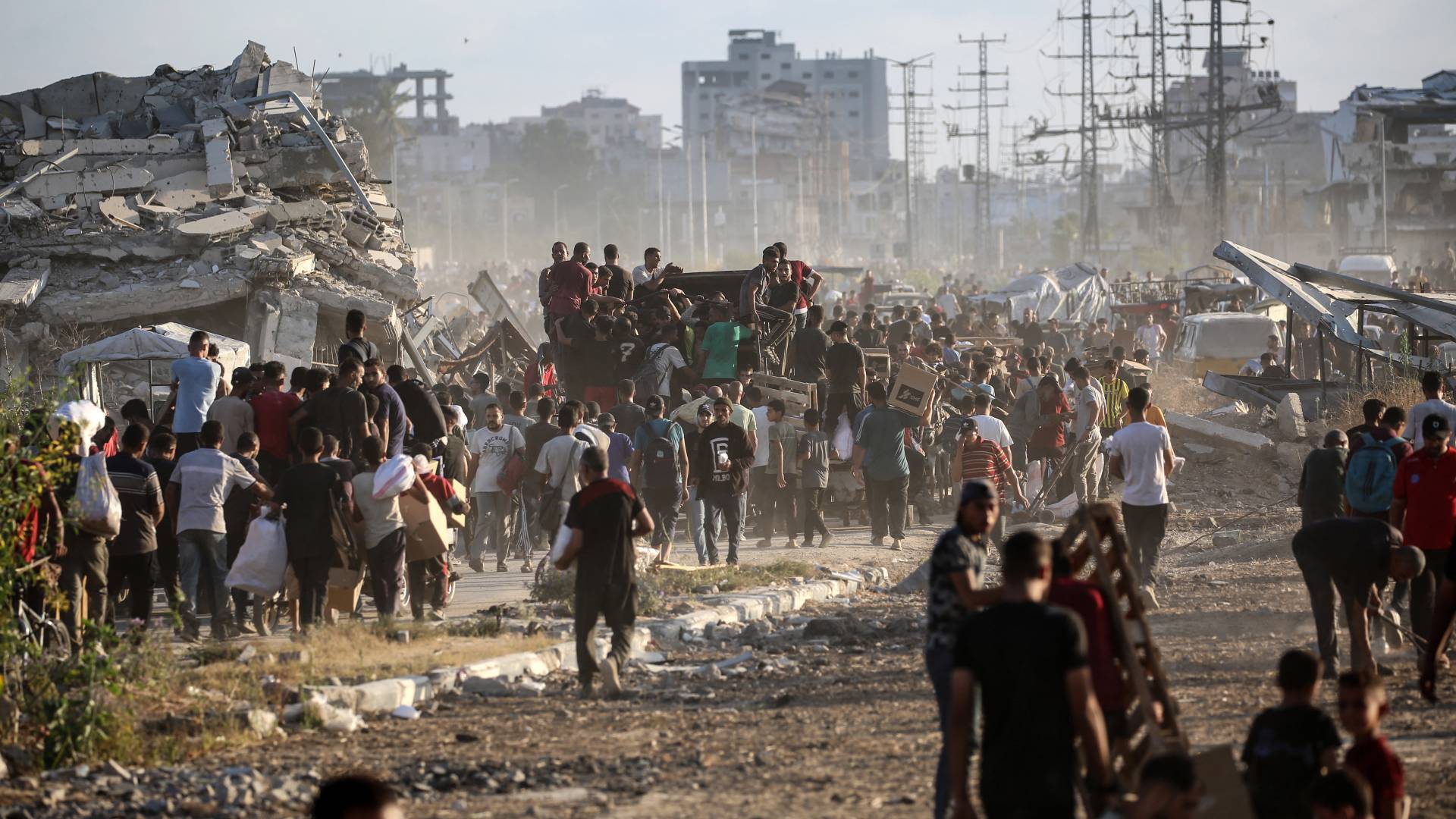 فلسطينيون يحملون مساعدات انسانية على طريق صلاح الدين قرب مخيم النصيرات وسط القطاع