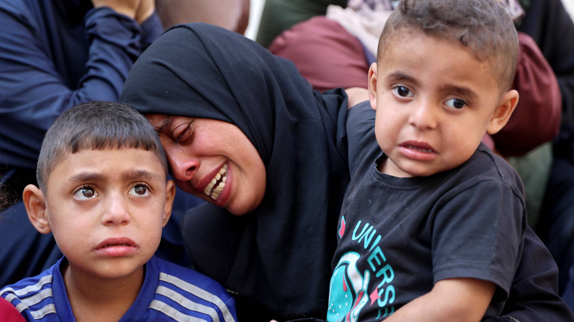 فلسطينية وأطفالها يبكون أحد أفراد عائلتهم