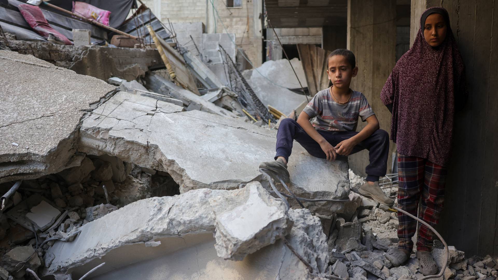 طفل وطفلة بين ركام منزلهما في غزة