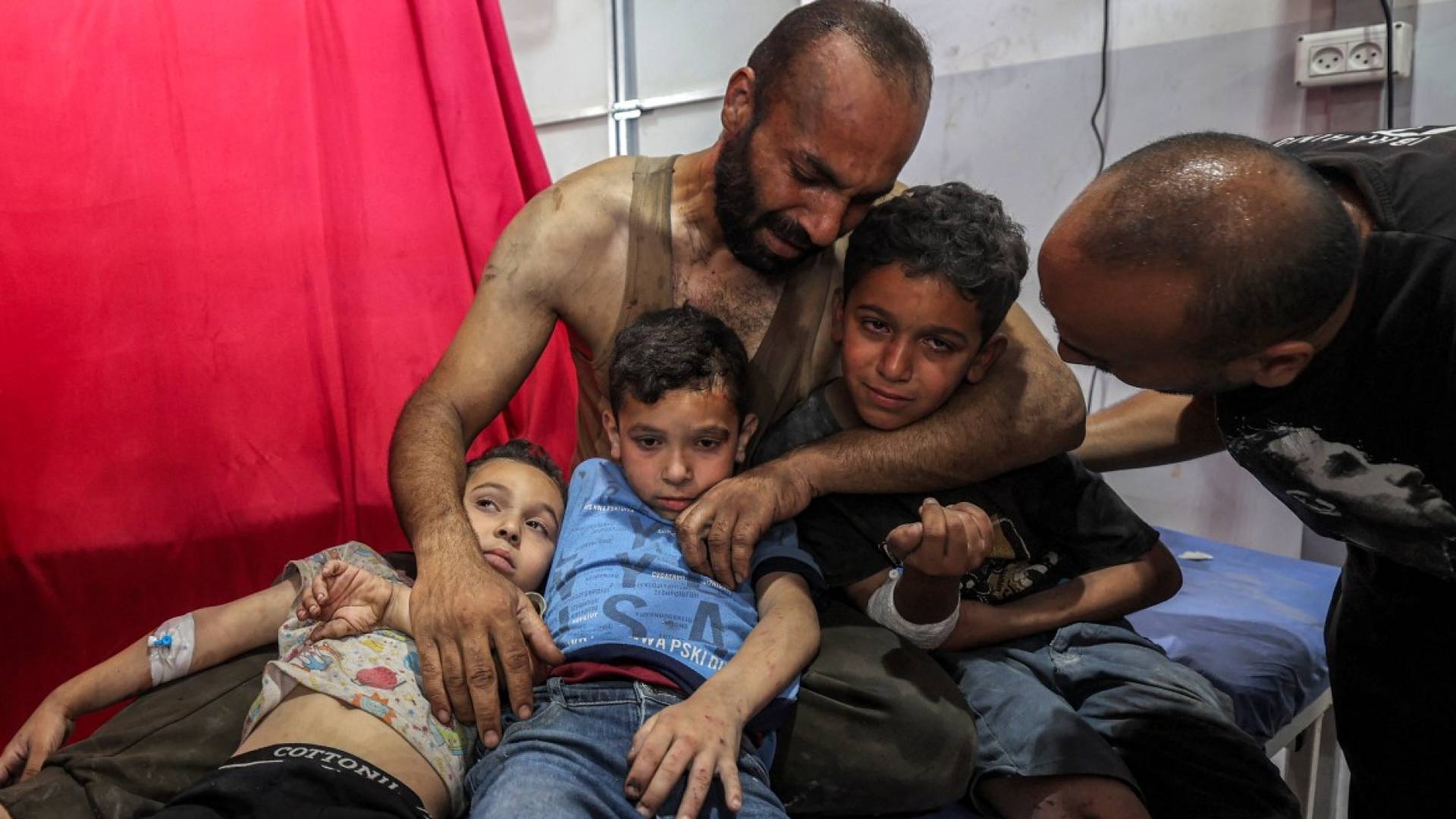 أب يتحول إلى جدار حماية لأطفاله المصابين في مشهد يُبكي الحجر في غزة