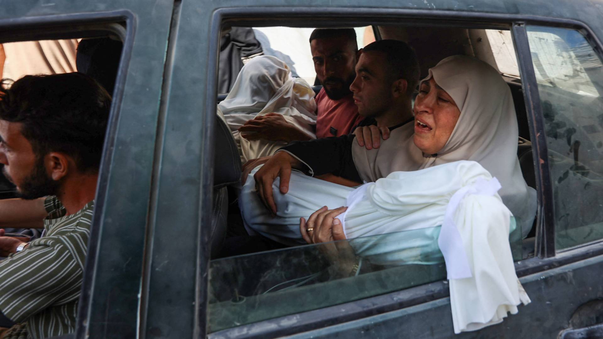 فلسطينية تحمل جثمان ابنها الشهيد في غزة