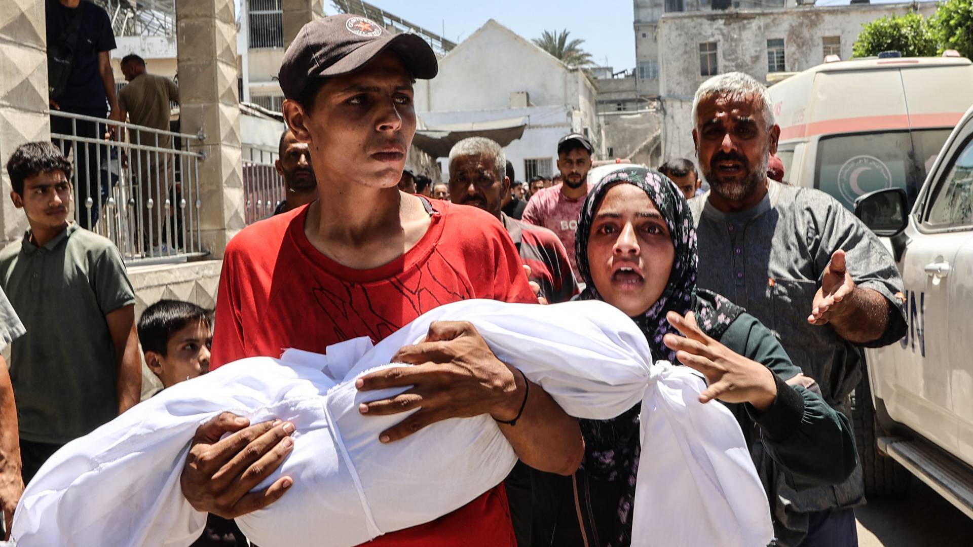 فلسطيني يحمل جثمان طفله الشهيد في غزة