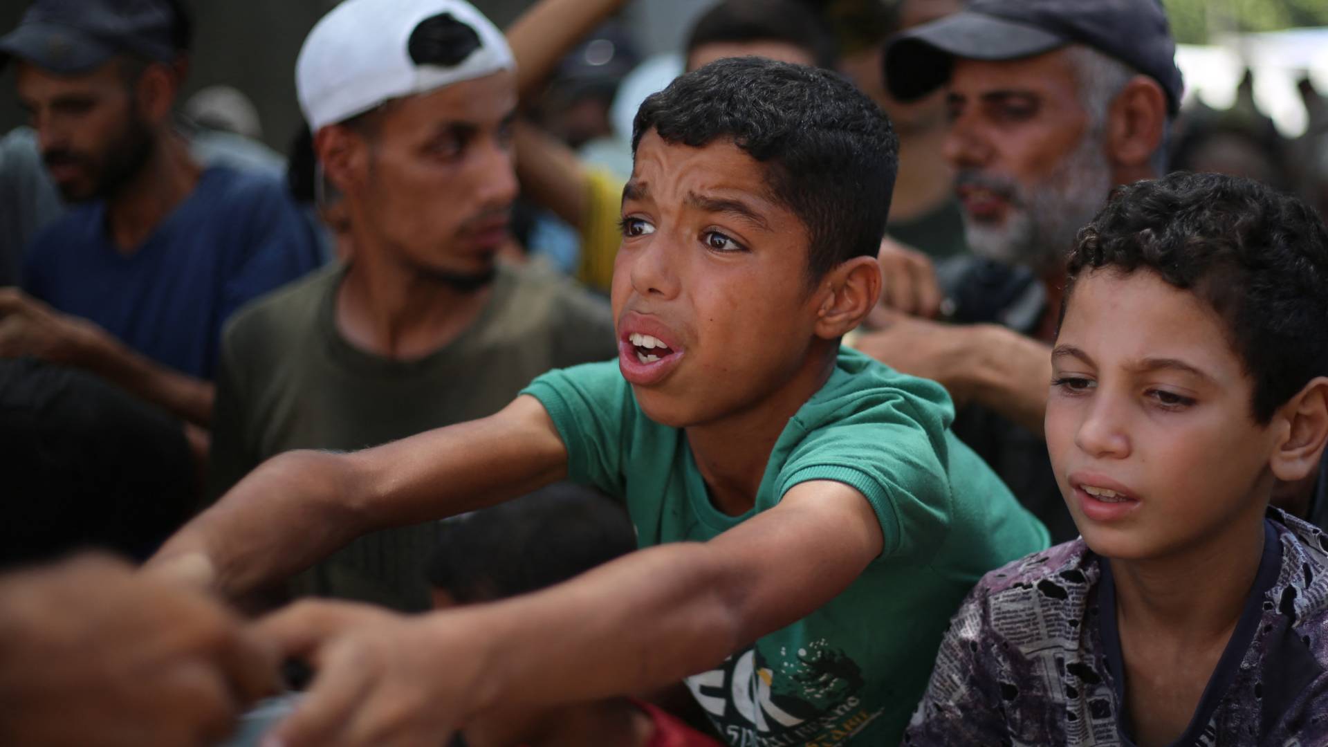 أطفال فلسطينيون يطلبون الغذاء في مخيم النصيرات للاجئين في وسط قطاع غزة