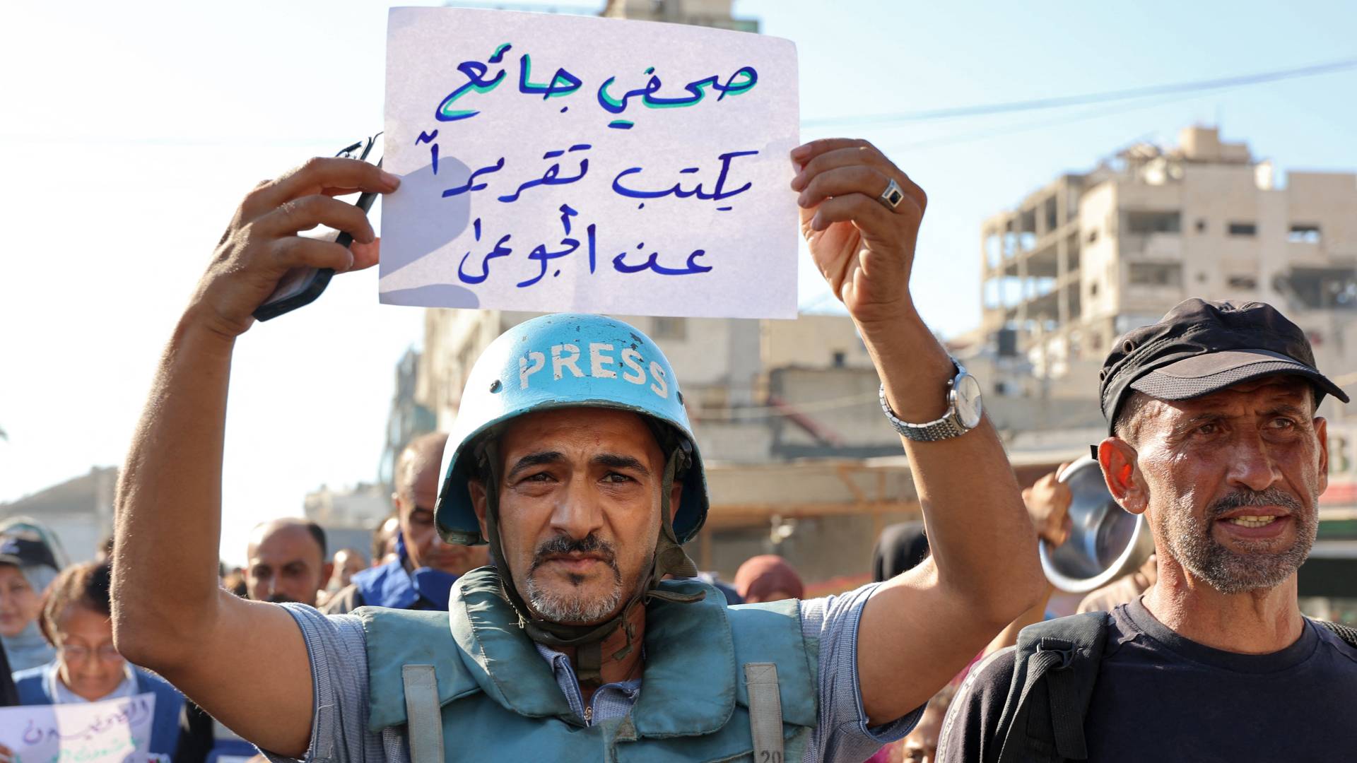 صحفي فلسطيني يرفع شعار "صحفي جائع يكتب تقريرا عن الجوعى"