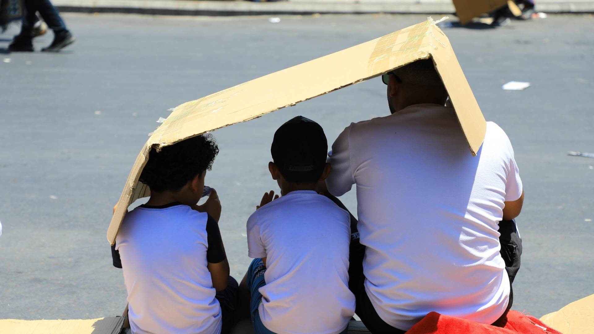 شخص وأبناؤه في الأجواء الحارة في الأردن