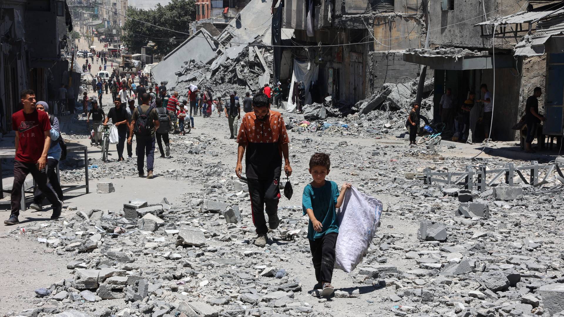 فلسطينيون بين أنقاض المباني التي دمرت في ضربات إسرائيلية على حي الدرج في مدينة غزة