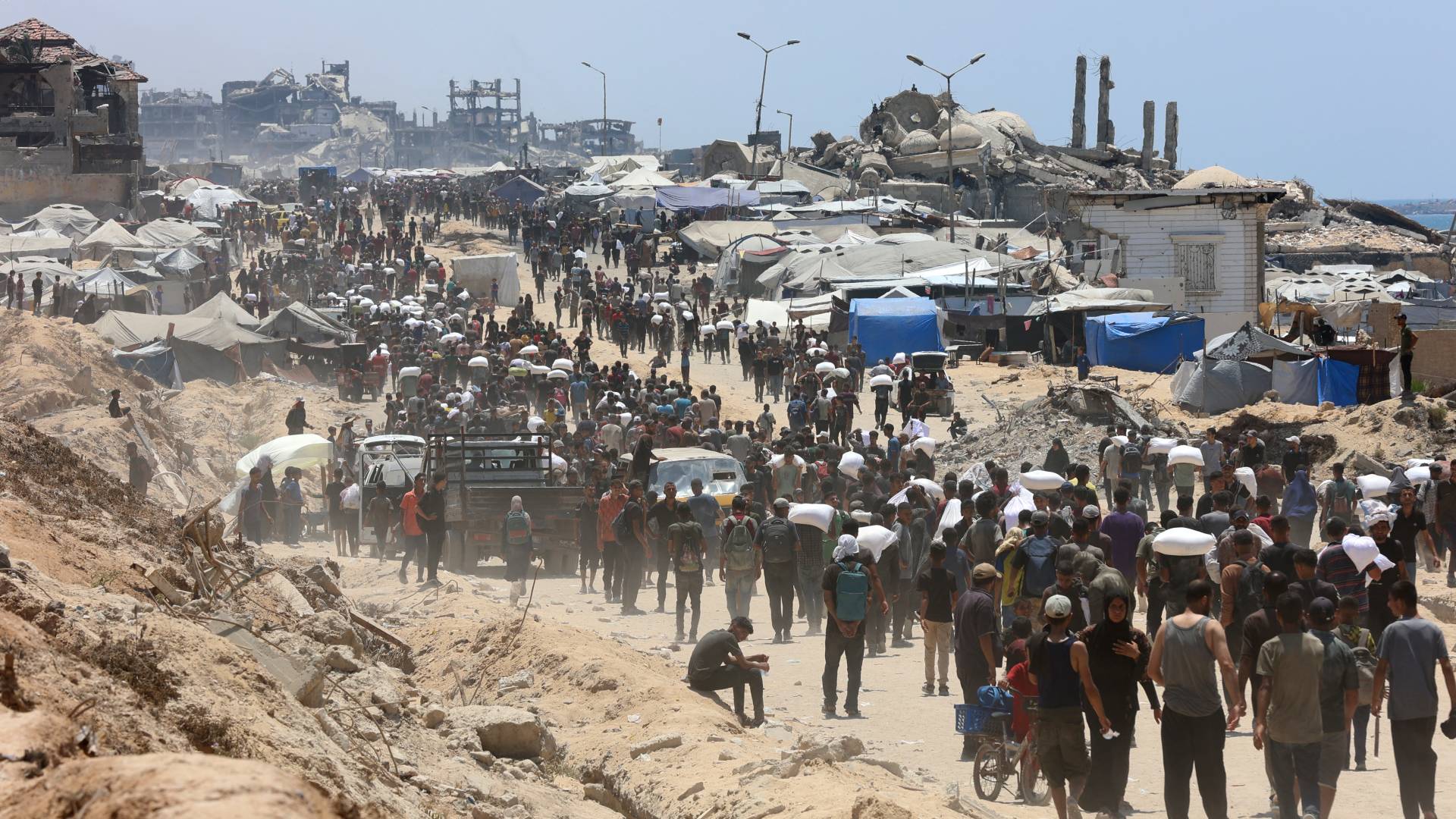 فلسطينيون يحملون أكياس طحين