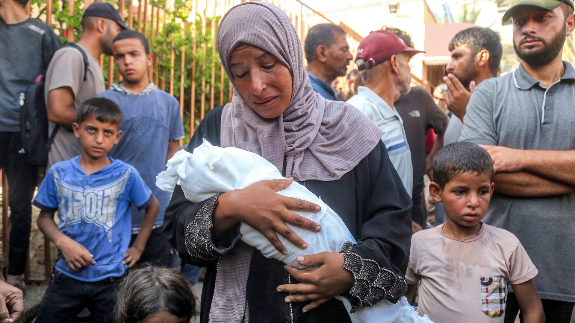 فلسطينية تحمل طفلها الشهيد في غزة