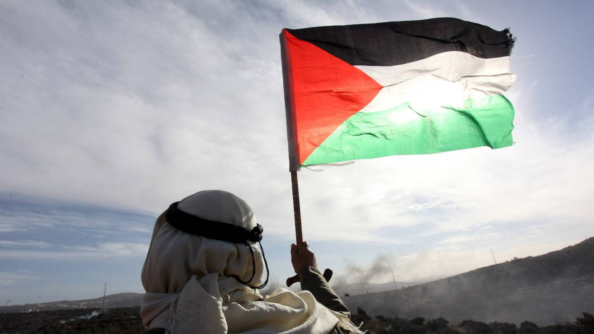 رجل يرفع العلم الفلسطيني