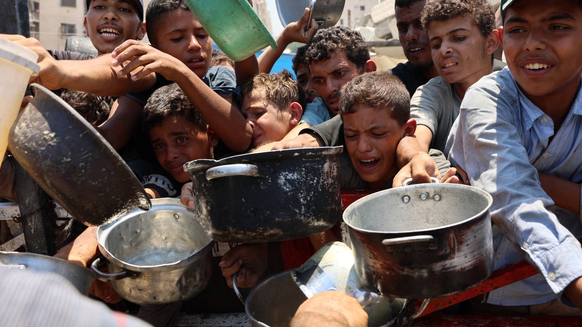 فلسطينيون ينتظرون حصولهم على القليل من الطعام في غزة