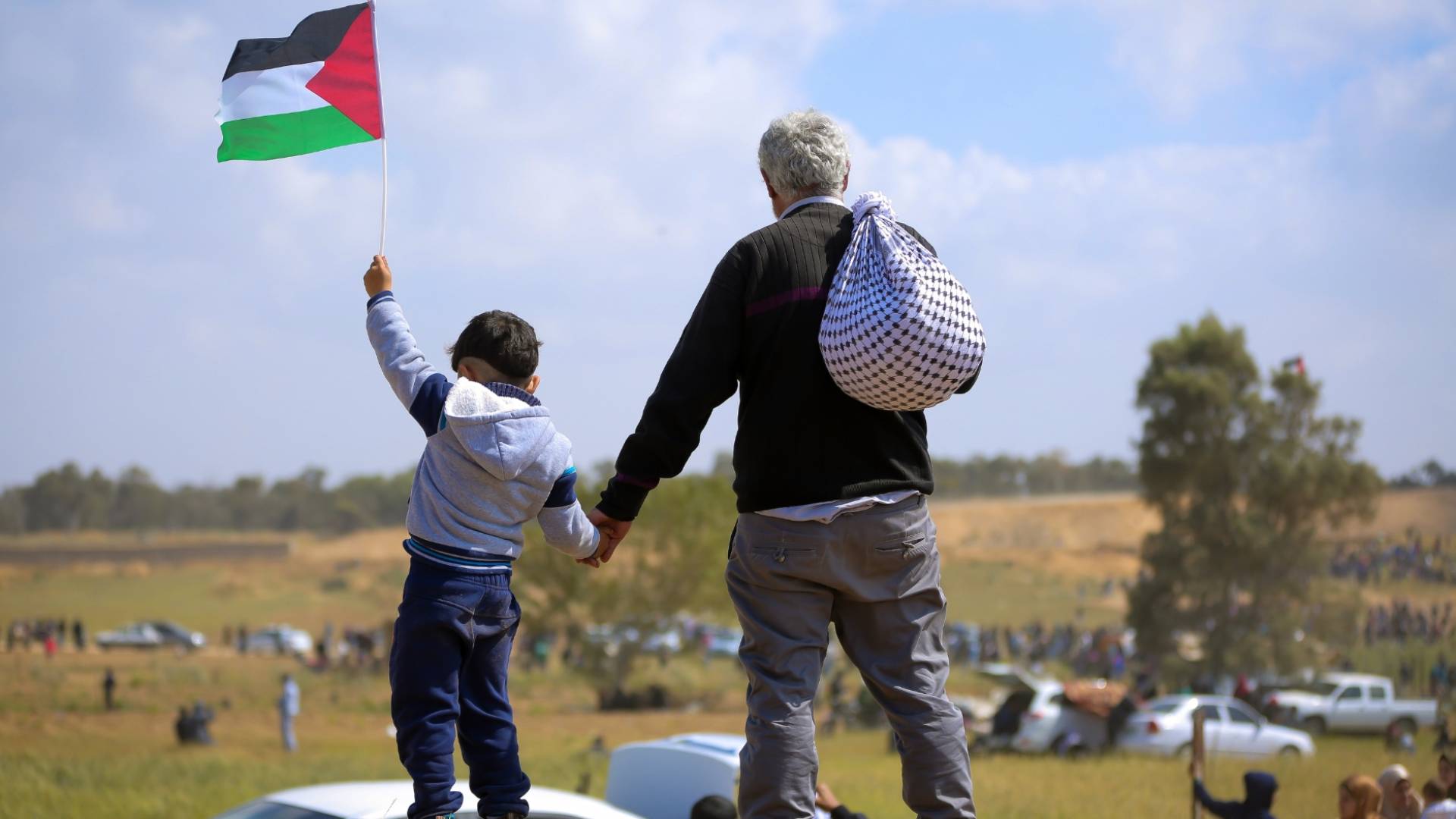 فلسطيني ونجله يرفع علم فلسطين