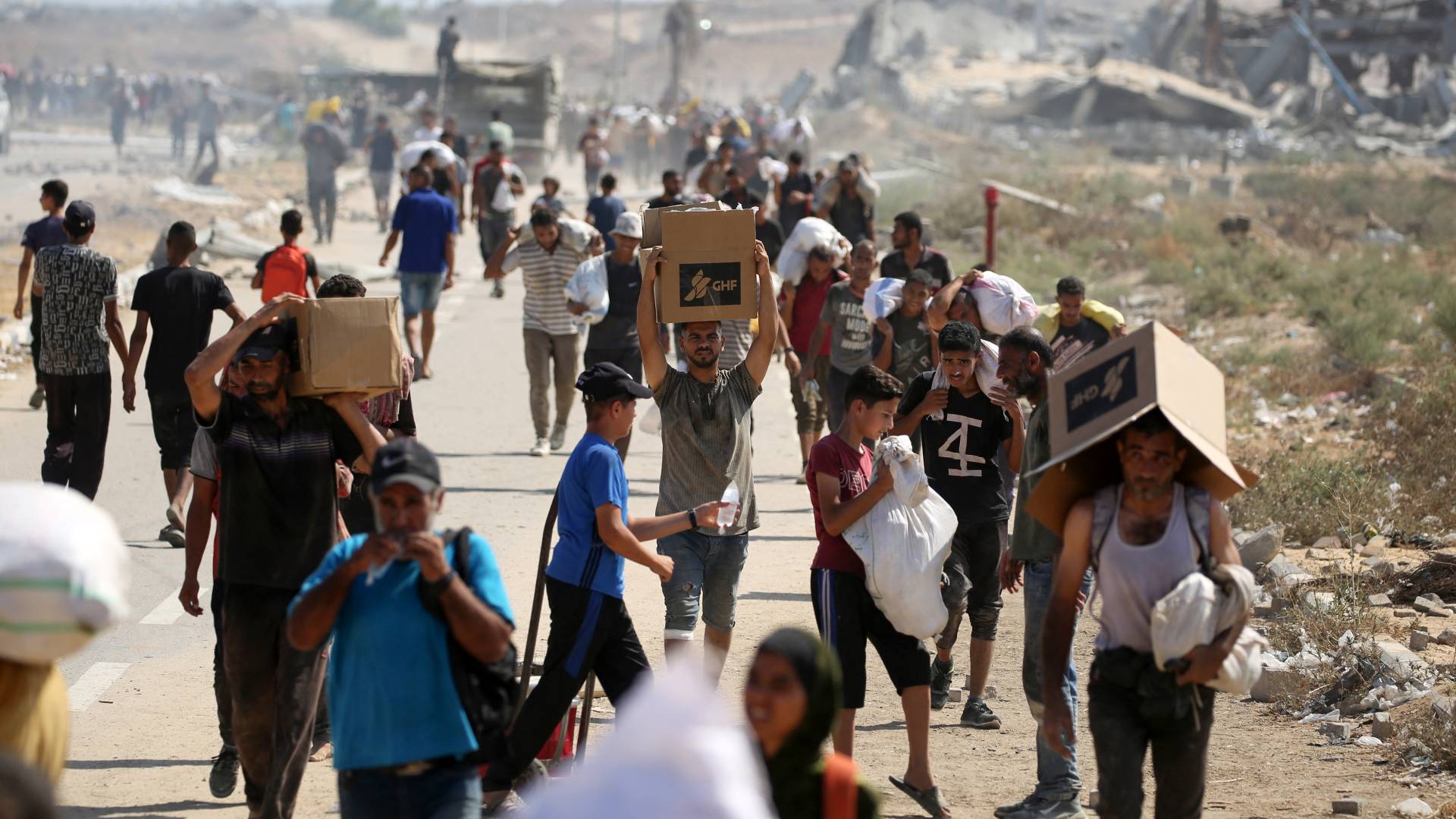 فلسطينيون يتلقون مساعدات إنسانية من نقطة توزيع مساعدات