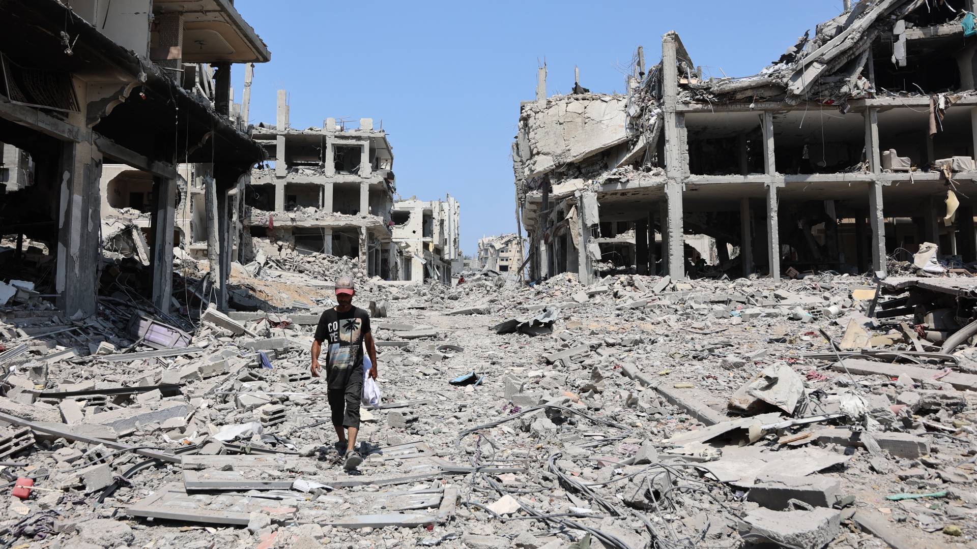 رجل فلسطيني يمر بجانب مبان مدمرة في حي التفاح بمدينة غزة