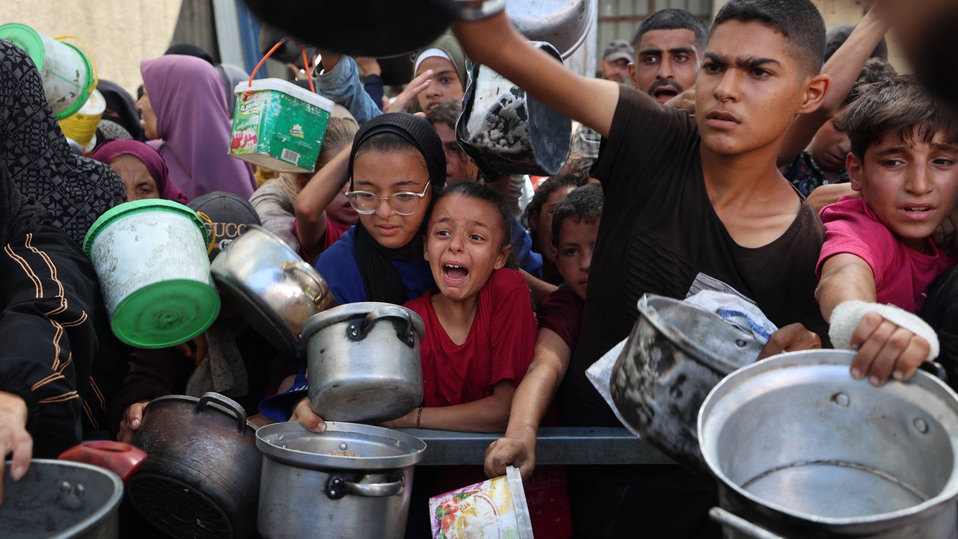 فلسطينيون يتلقون مساعدات غذائية في مخيم النصيرات في غزة