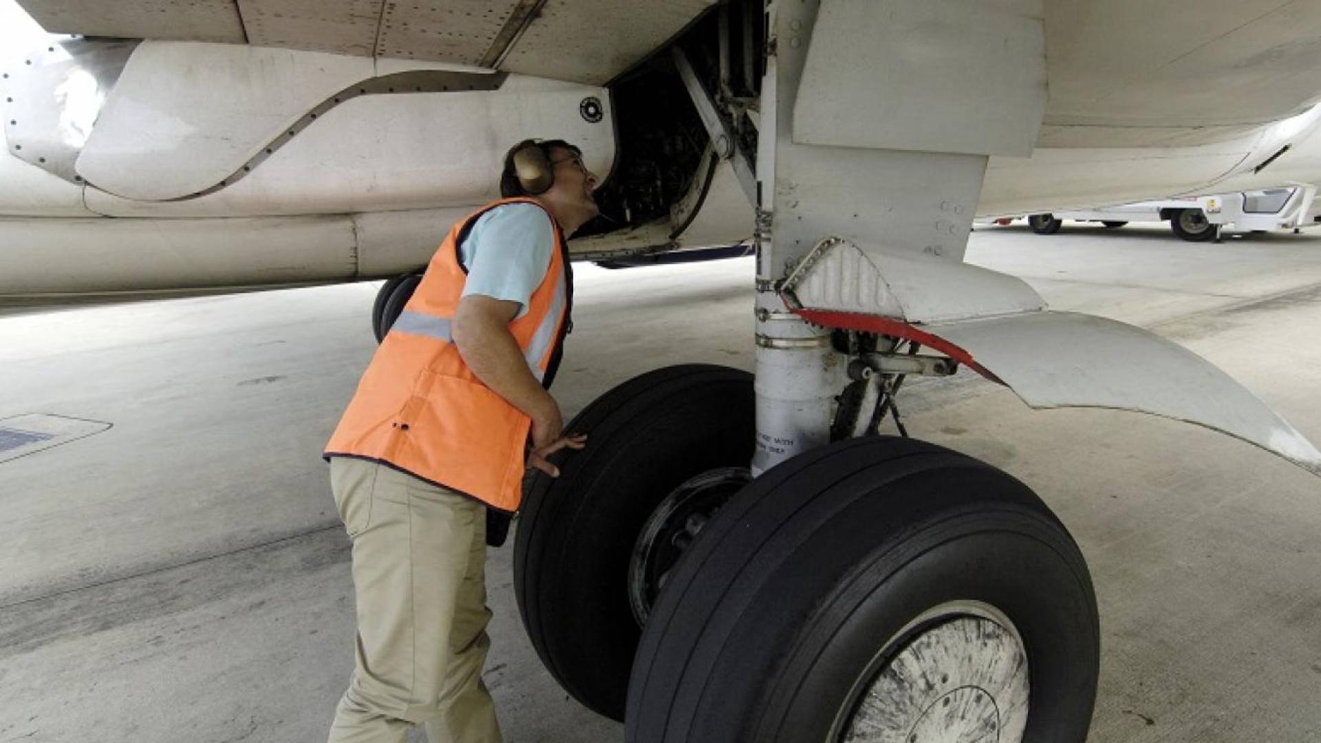 ارشيفية.. موظف في احد المطارات يتفقد عجلات  طائرة