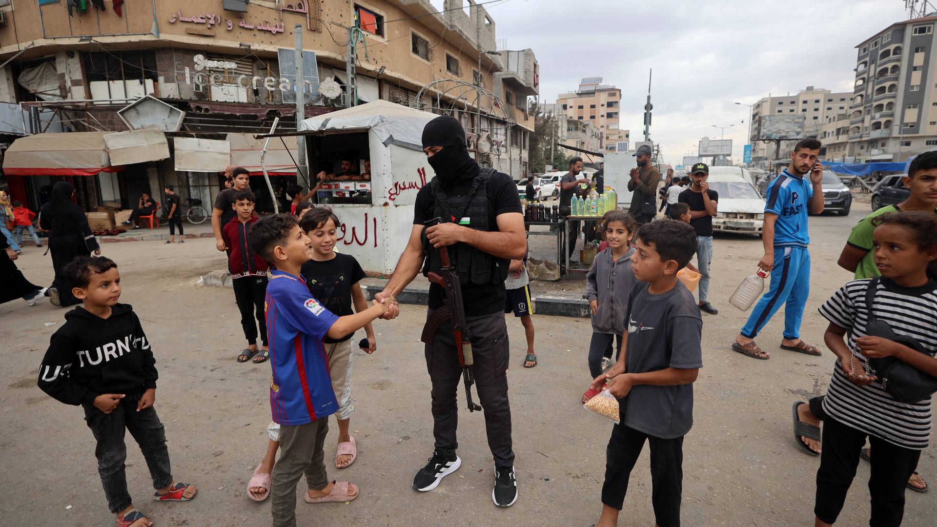 عنصر من المقاومة الفلسطينية مع أطفال غزة