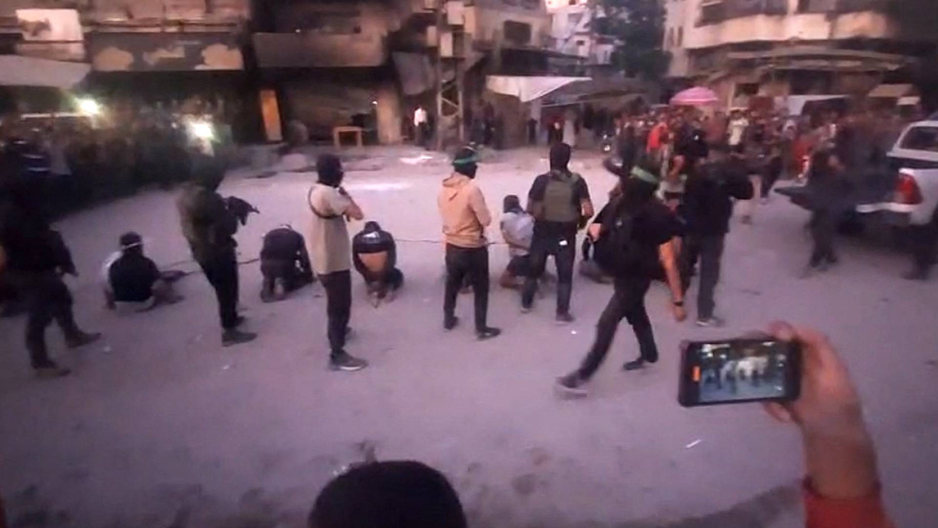 وقوف عناصر من حماس خلف رجال معصوبي الأعين ومقيدين