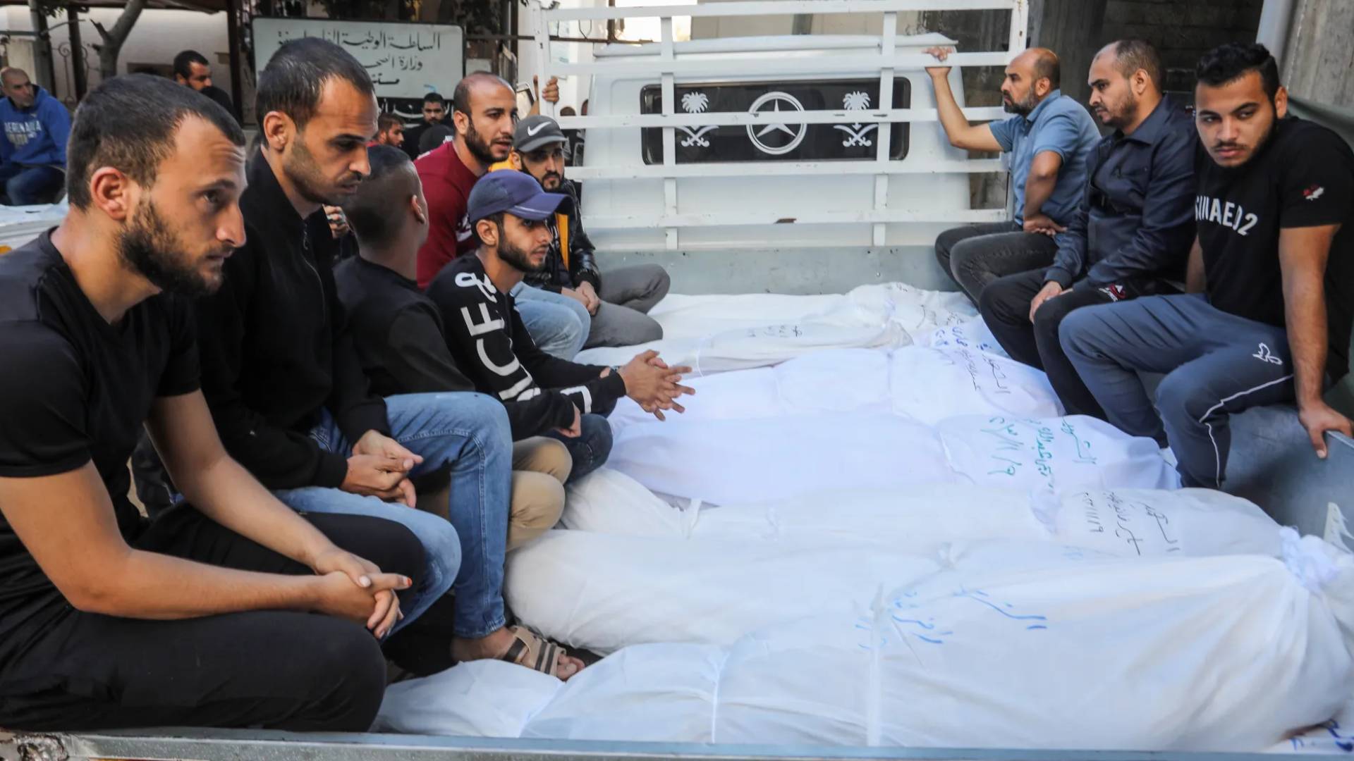 شباب فلسطينين ينقلون رفات شهداء في قطاع غزة بواسطة شاحنة
