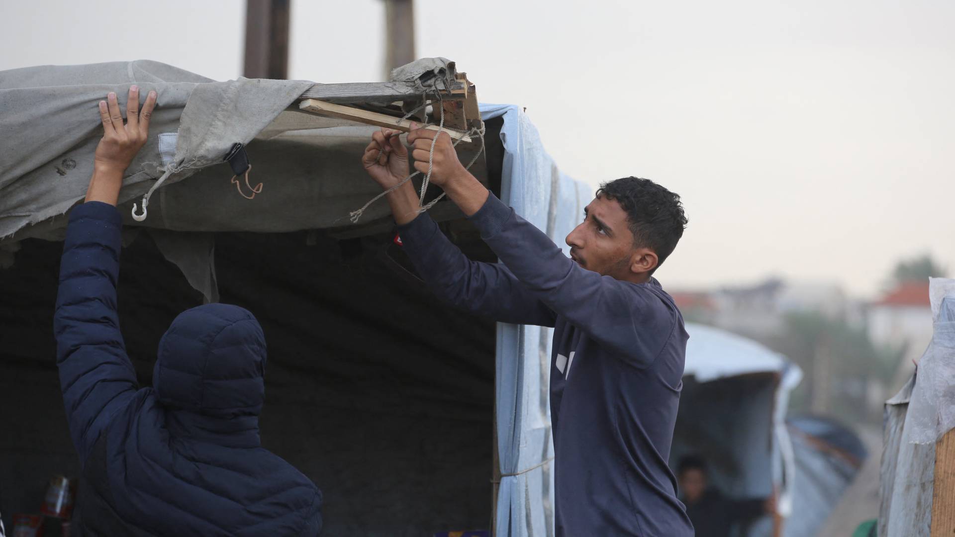 اهالي قطاع غزة يصلحون الخيم -أرشيفيه