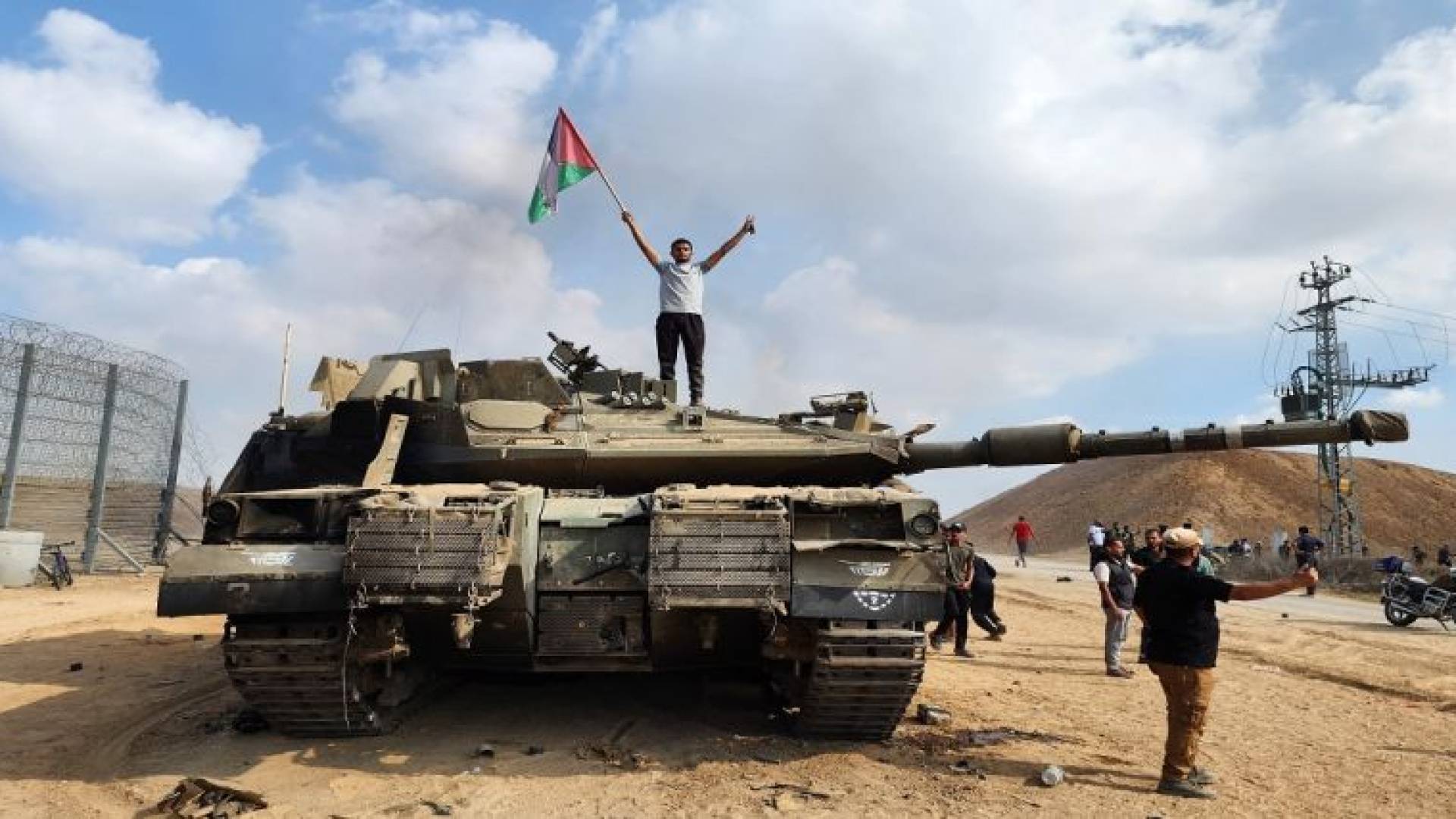 شاب فلسطيني يقف على آلية للاحتلال الإسرائيلي