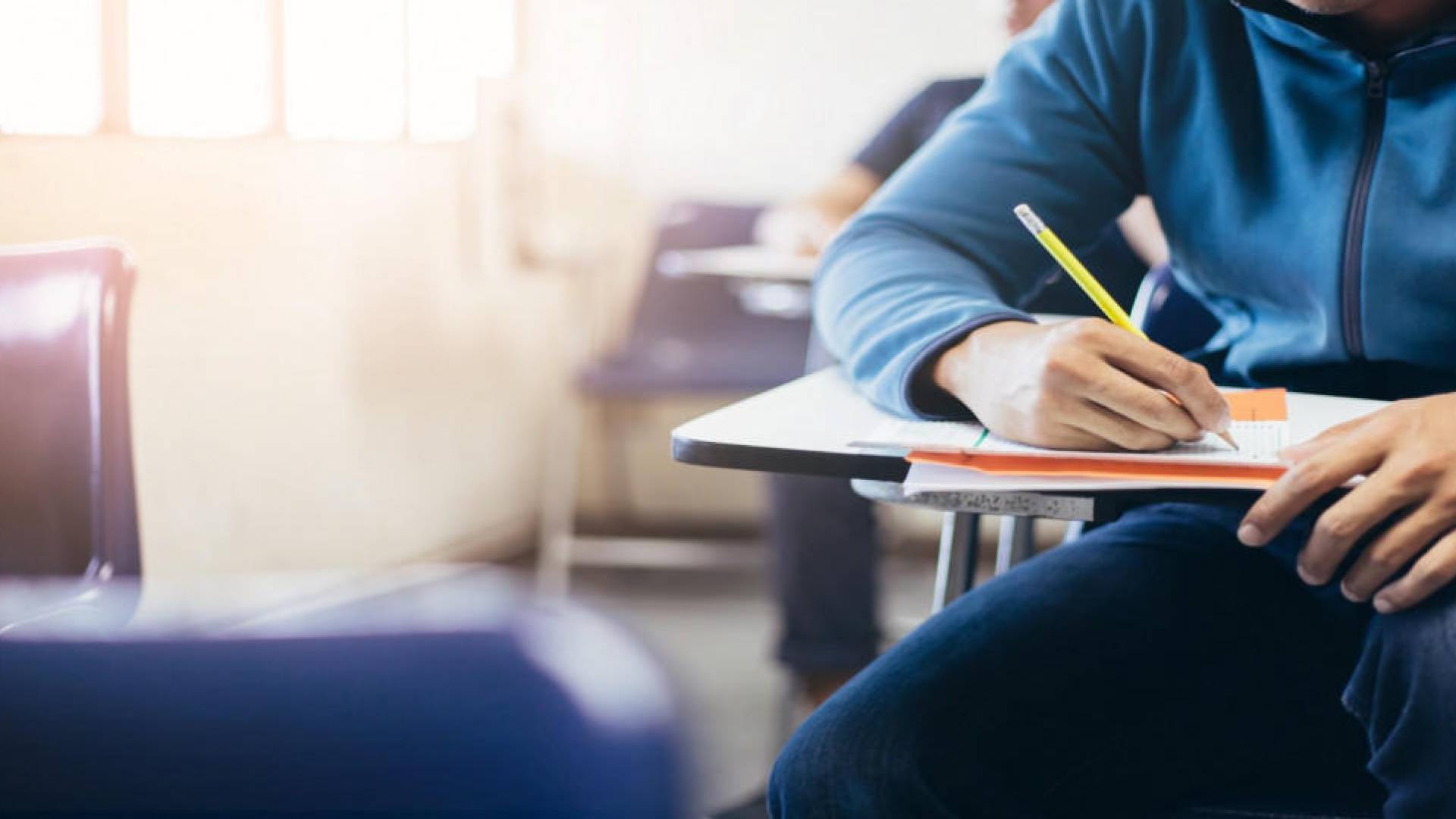 طالب يقدم امتحان على مقاعد الدراسة