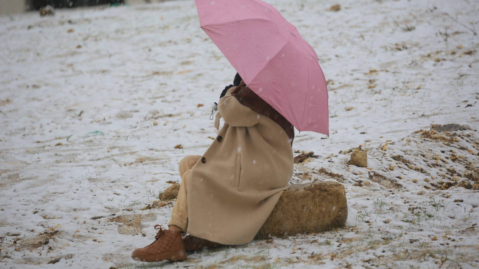 سيدة تجلس وسط الثلوج