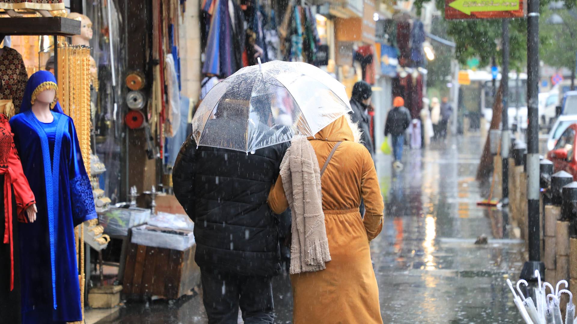 رجل و سيدة يسيران تحت المطر