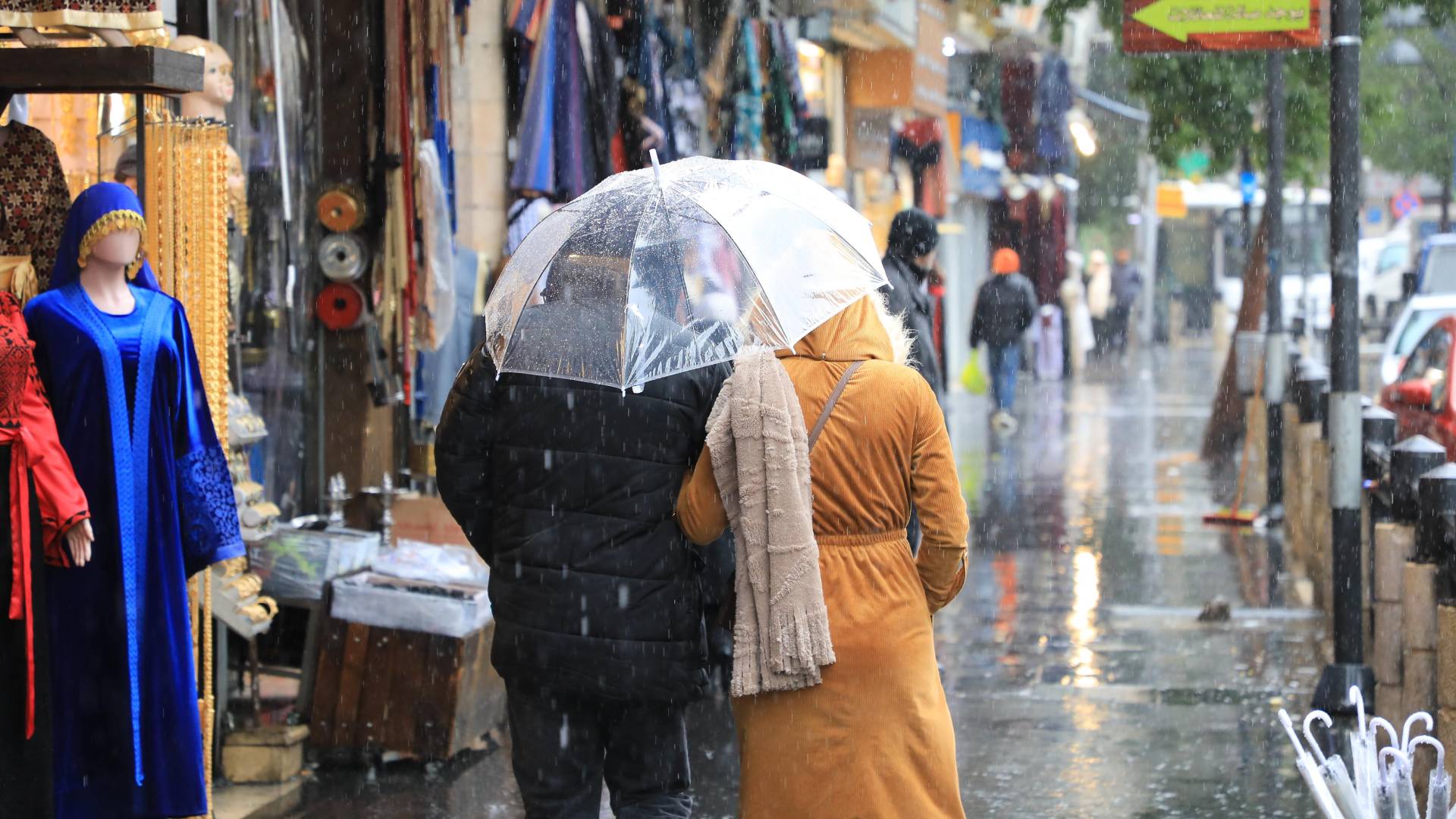 رجل و سيدة يسيران تحت المطر