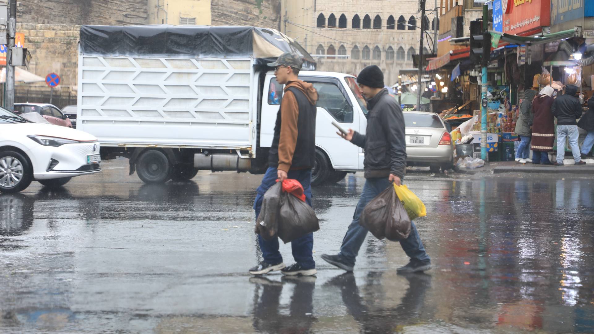 رجلان يسيران في احدى شوارع العاصمة عمان