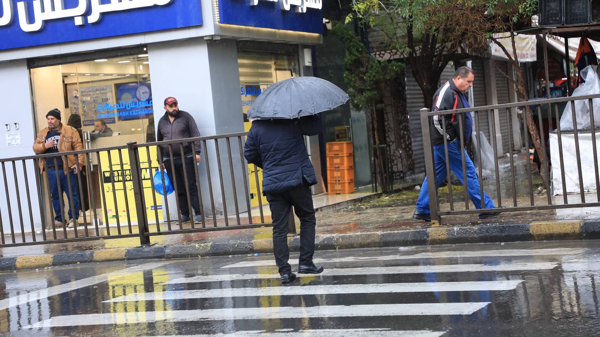 رجل يسير في شوارع العاصمة عمان في الشتاء