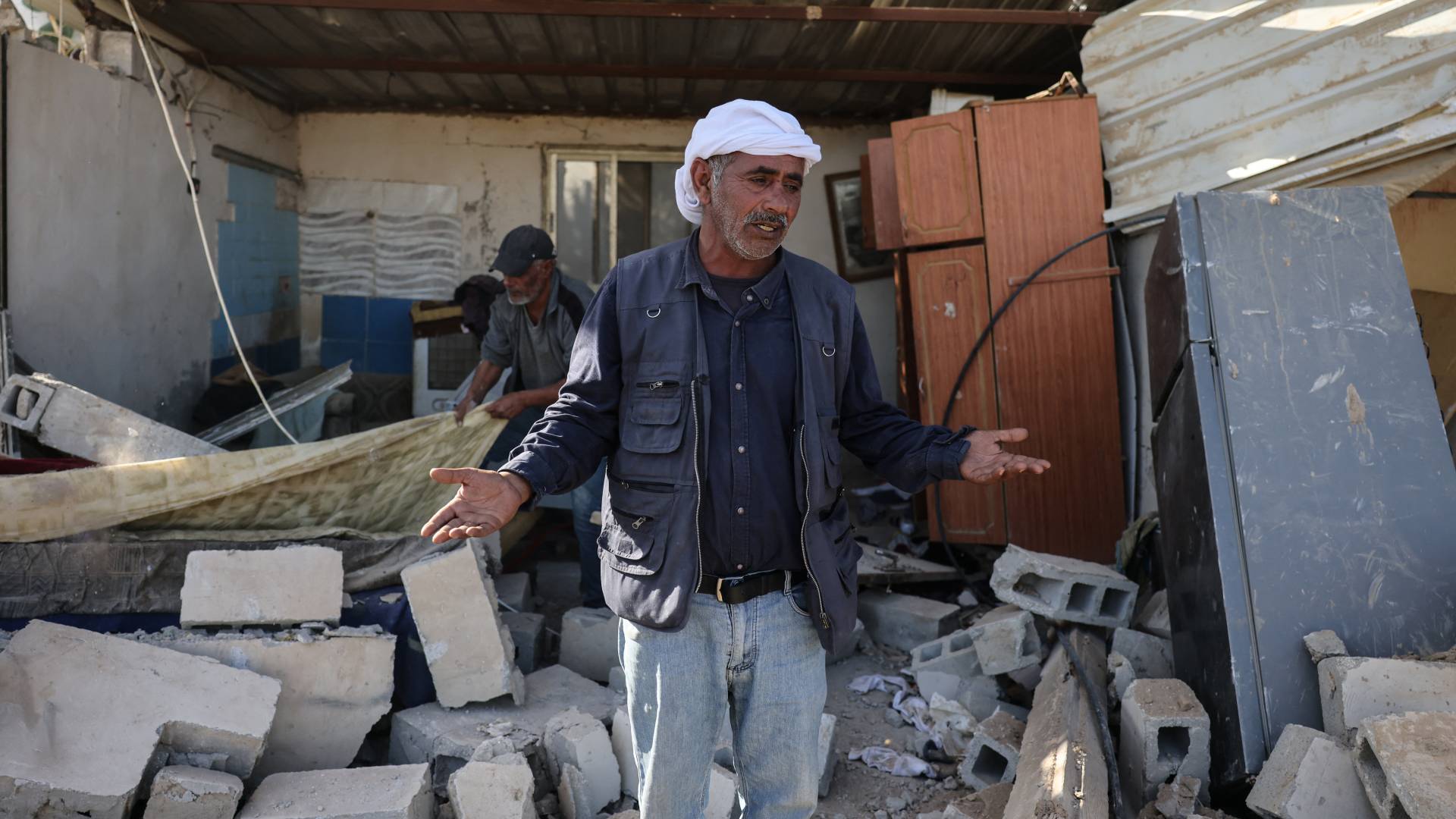 مواطن فلسطيني وسط بيته المهدم
