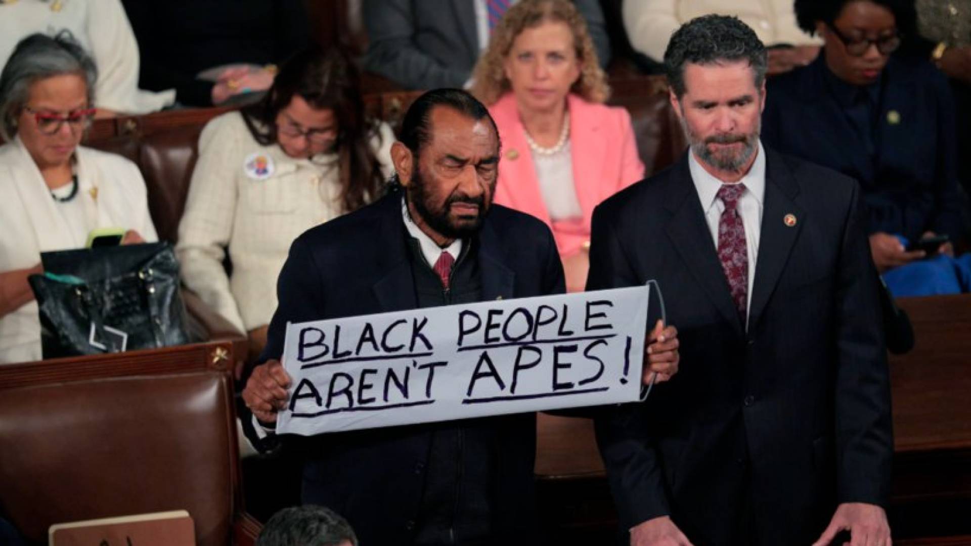 النائب الديمقراطي آل غرين  يحمل لافتة مكتوب عليها "السود ليسوا قرودا"