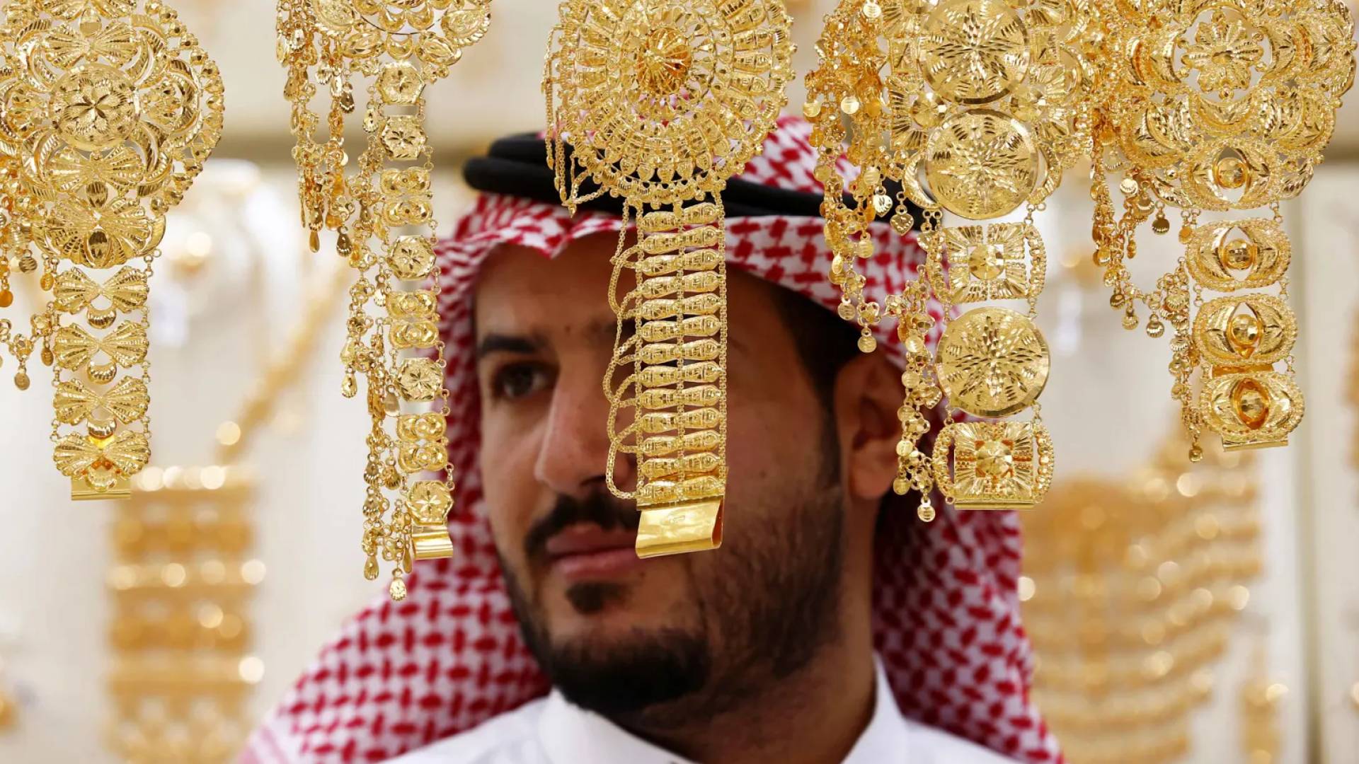 رجل يتفحص المعروضات داخل أحد متاجر الذهب في السعودية
