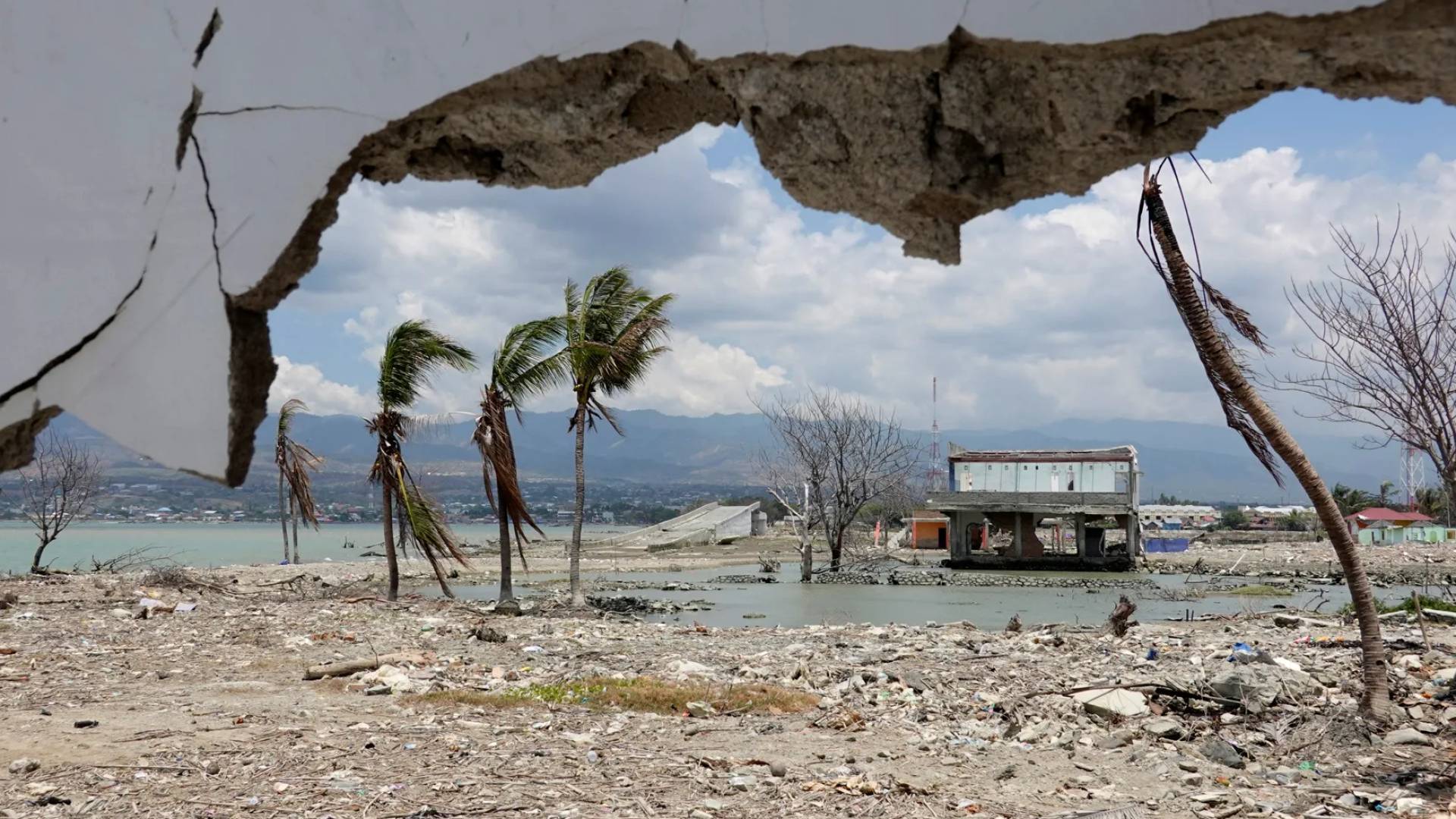 أطلال ومبنى متضرر بعد نحو عام من وقوع زلزال وتسونامي على شاطئ في بالو الإندونيسية