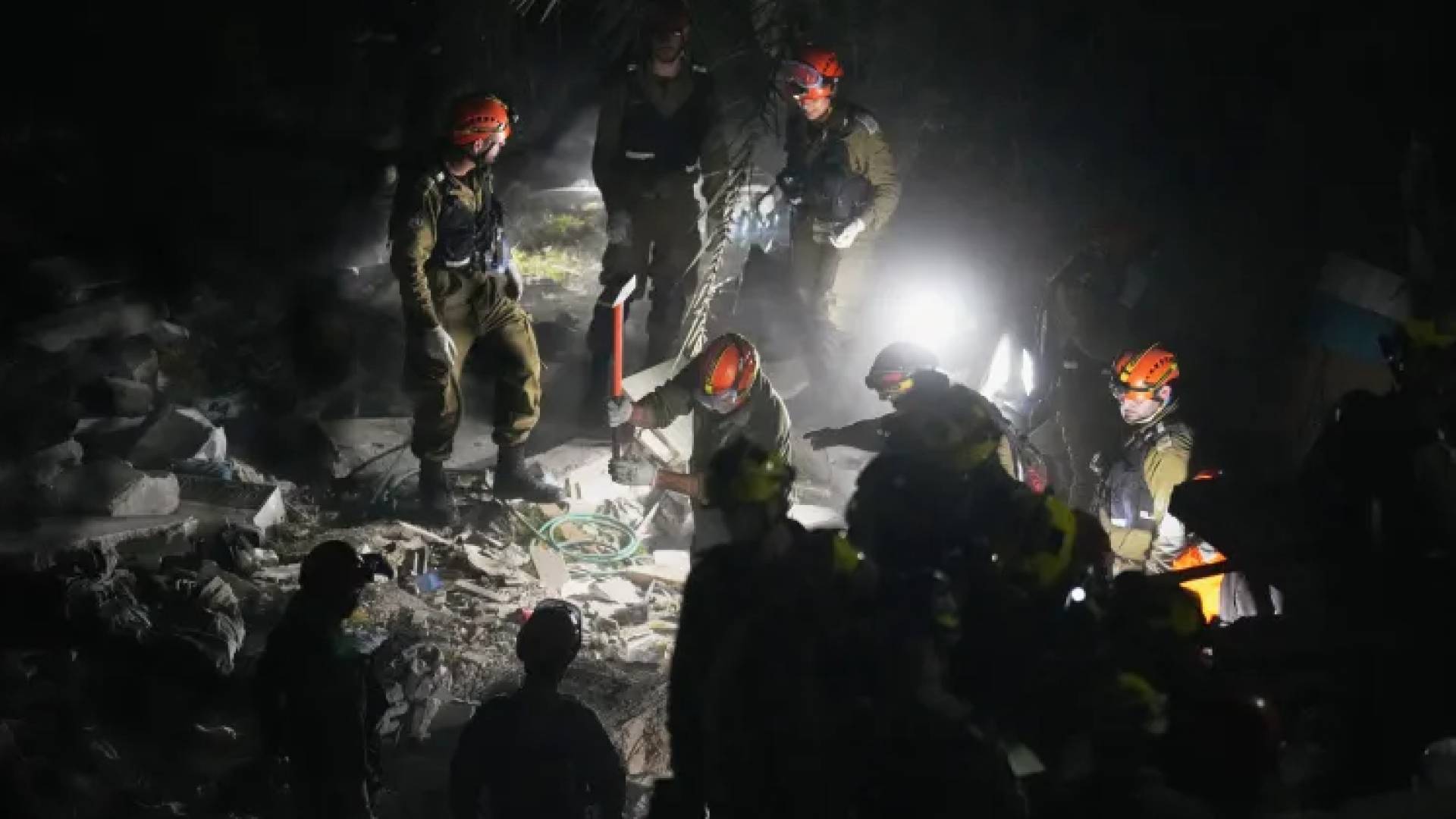 فرق الإنقاذ الإسرائيلية تعمل بين أنقاض مبنى في حيفا بعد قصف صاروخي