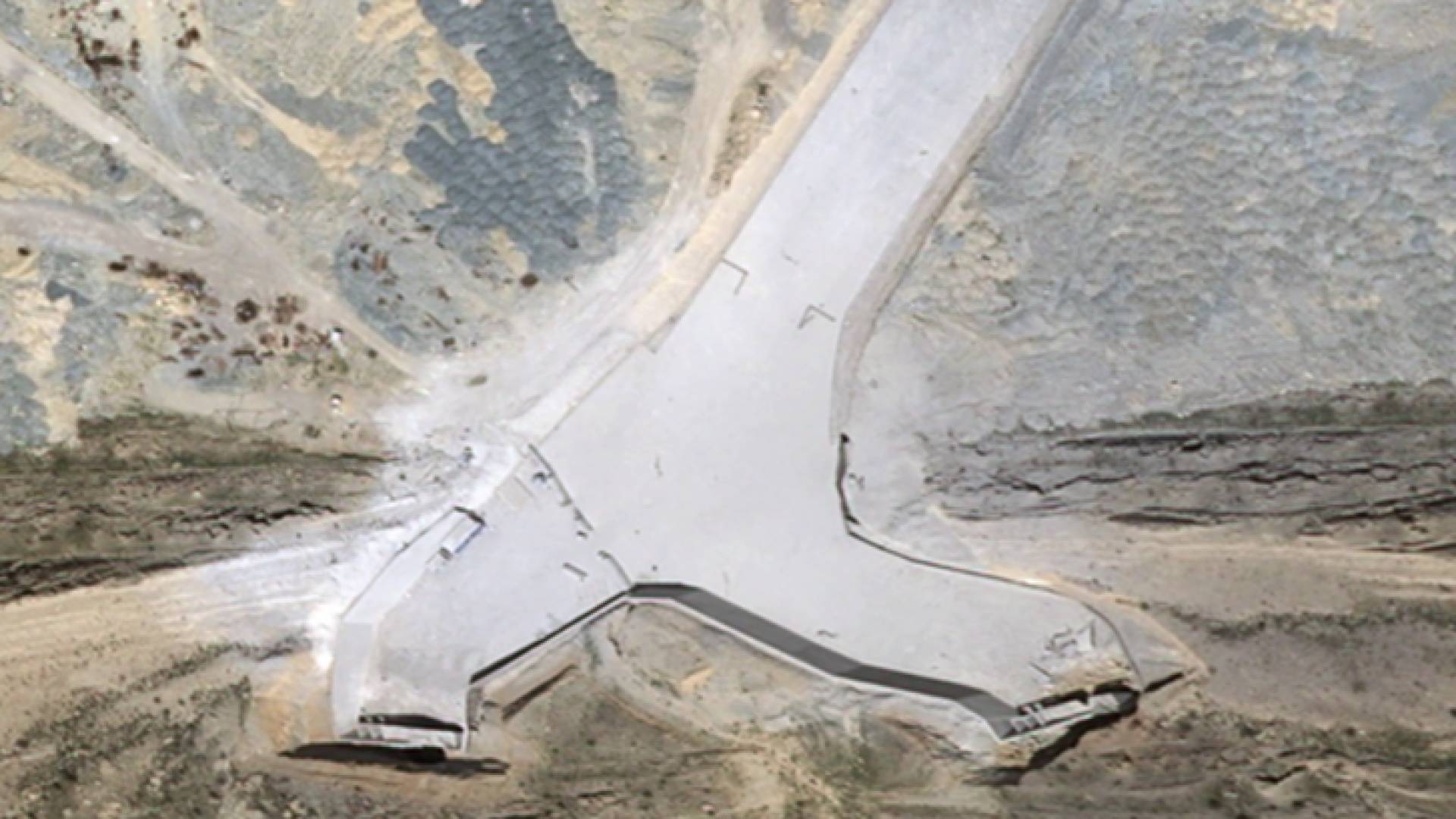 صورة التقطها قمر صناعي تظهر الأضرار في ممر الطائرات المؤدي إلى مداخل نفق المنشأة تحت الأرض