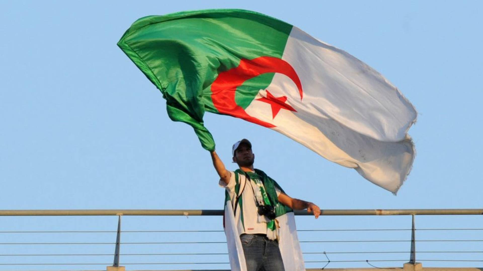 شخص يحمل العلم الجزائري