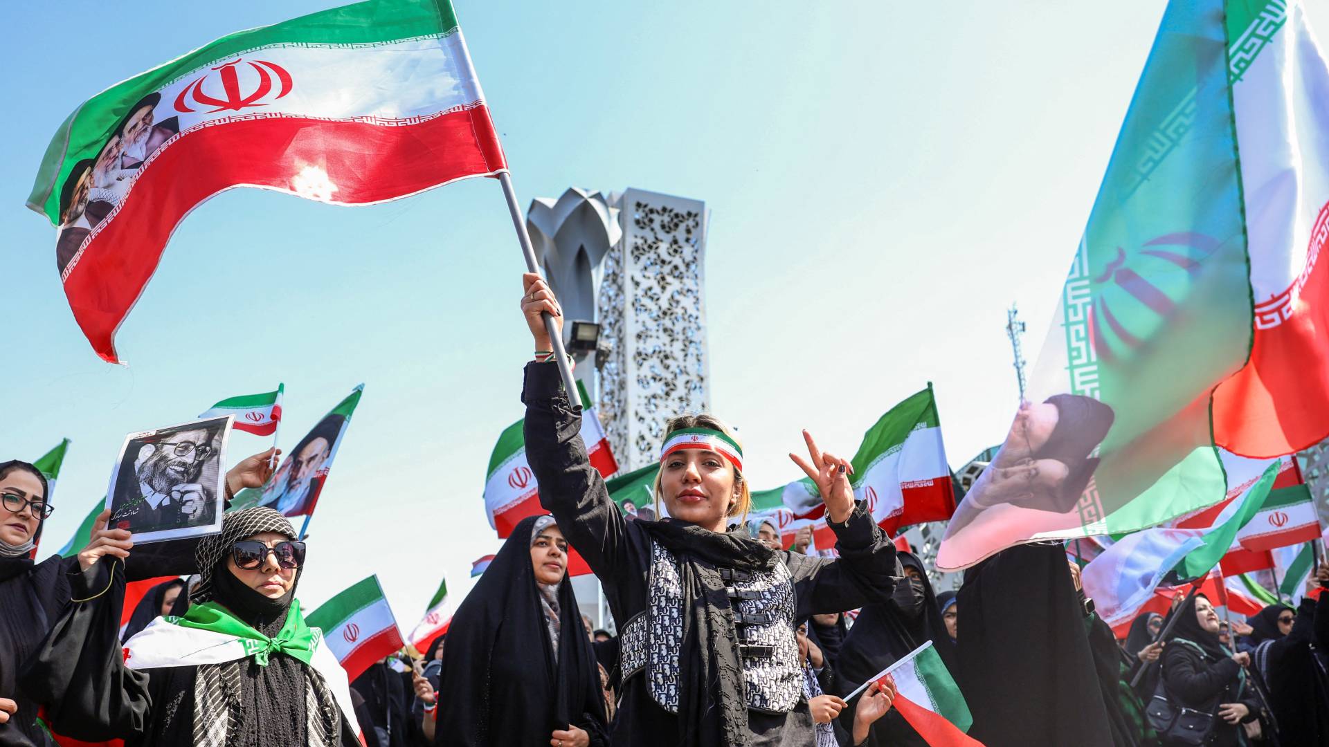 متظاهرون يحملون العلم الإيراني