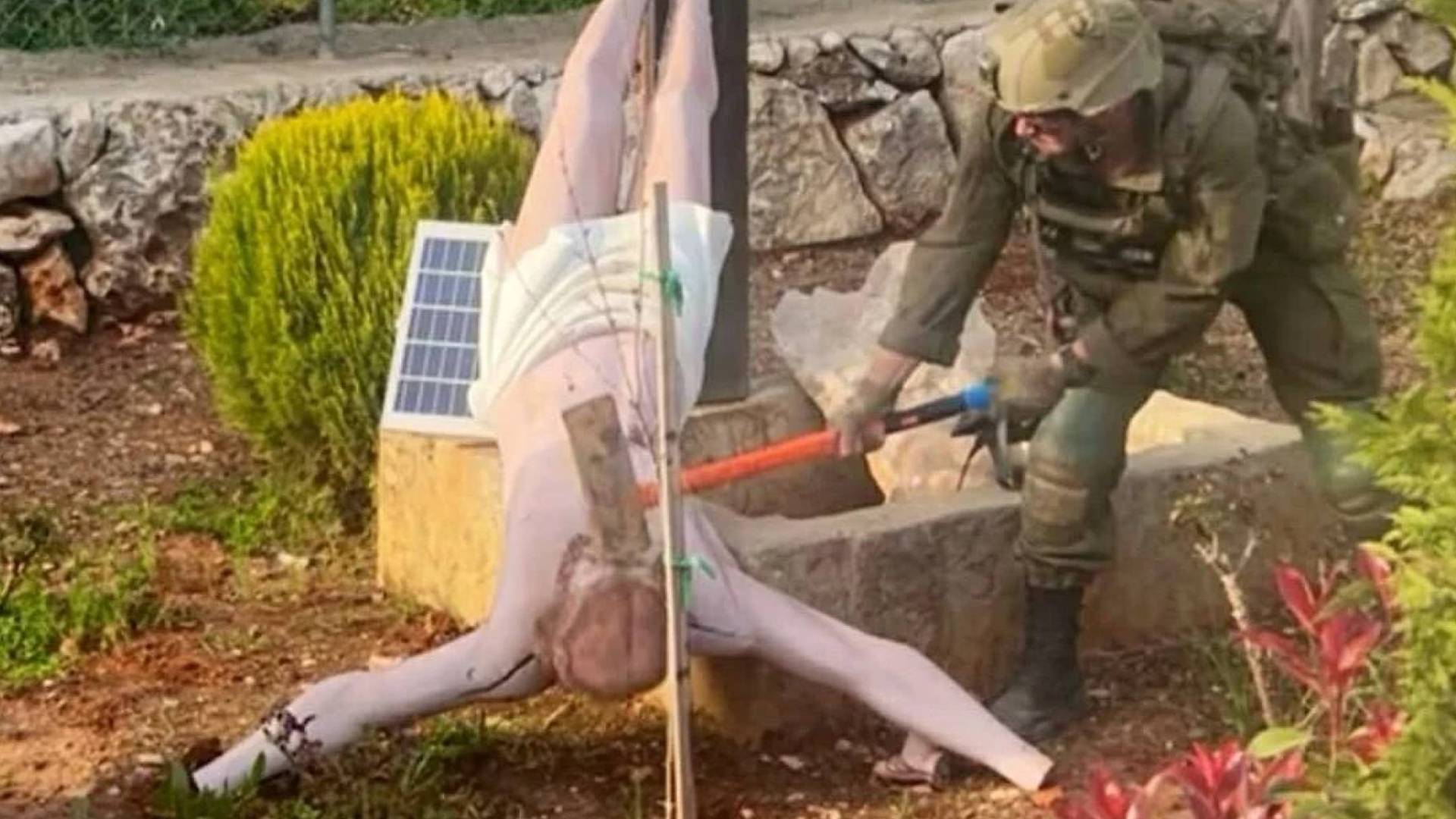 أحد جنود جيش الاحتلال يحطم تمثال السيد المسيح