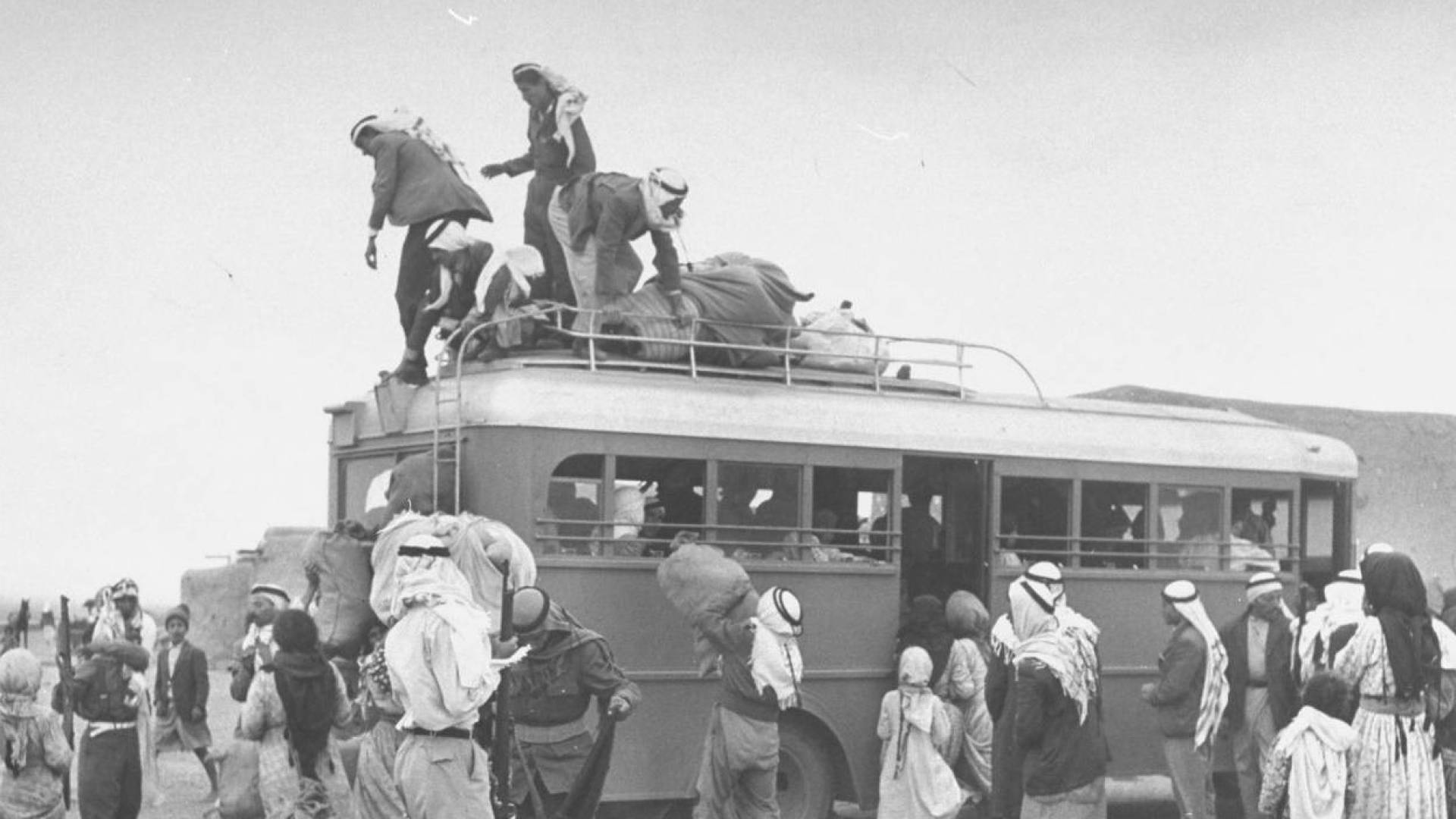 موطنون فلسطينيون  يحملون اغراضهم في يوم تهجيرهم  عام 1948