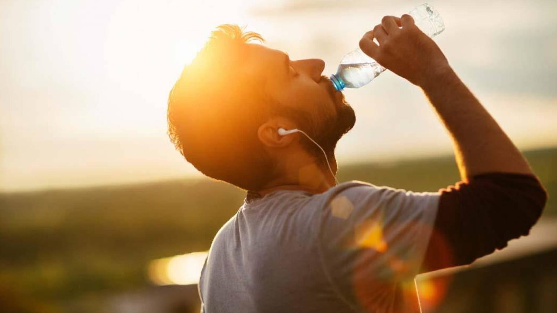 شاب يشرب مياه وسط حرارة الشمس