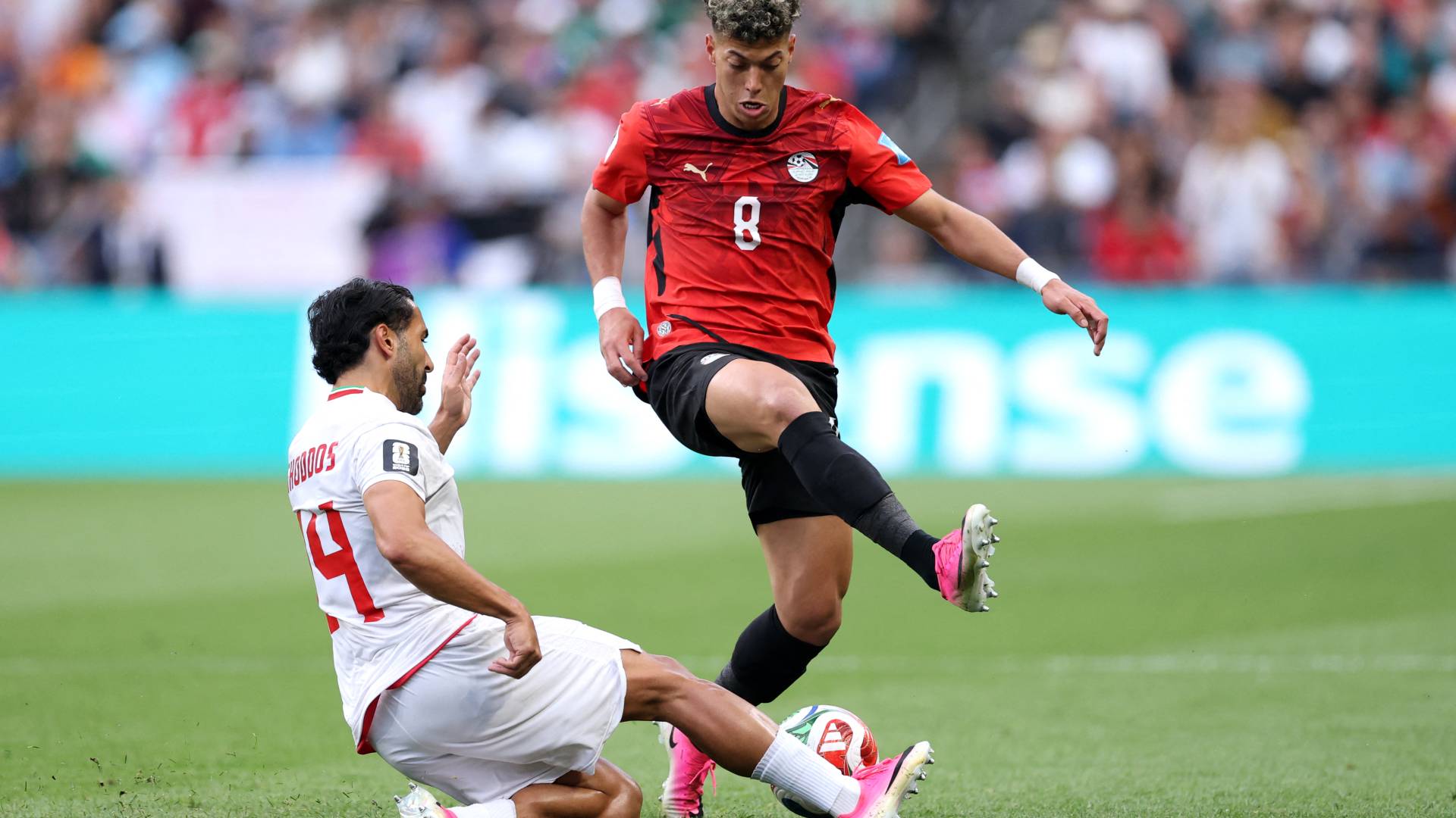 لاعب المنتخب المصري إمام عاشور أمام لاعب المنتخب الإيراني